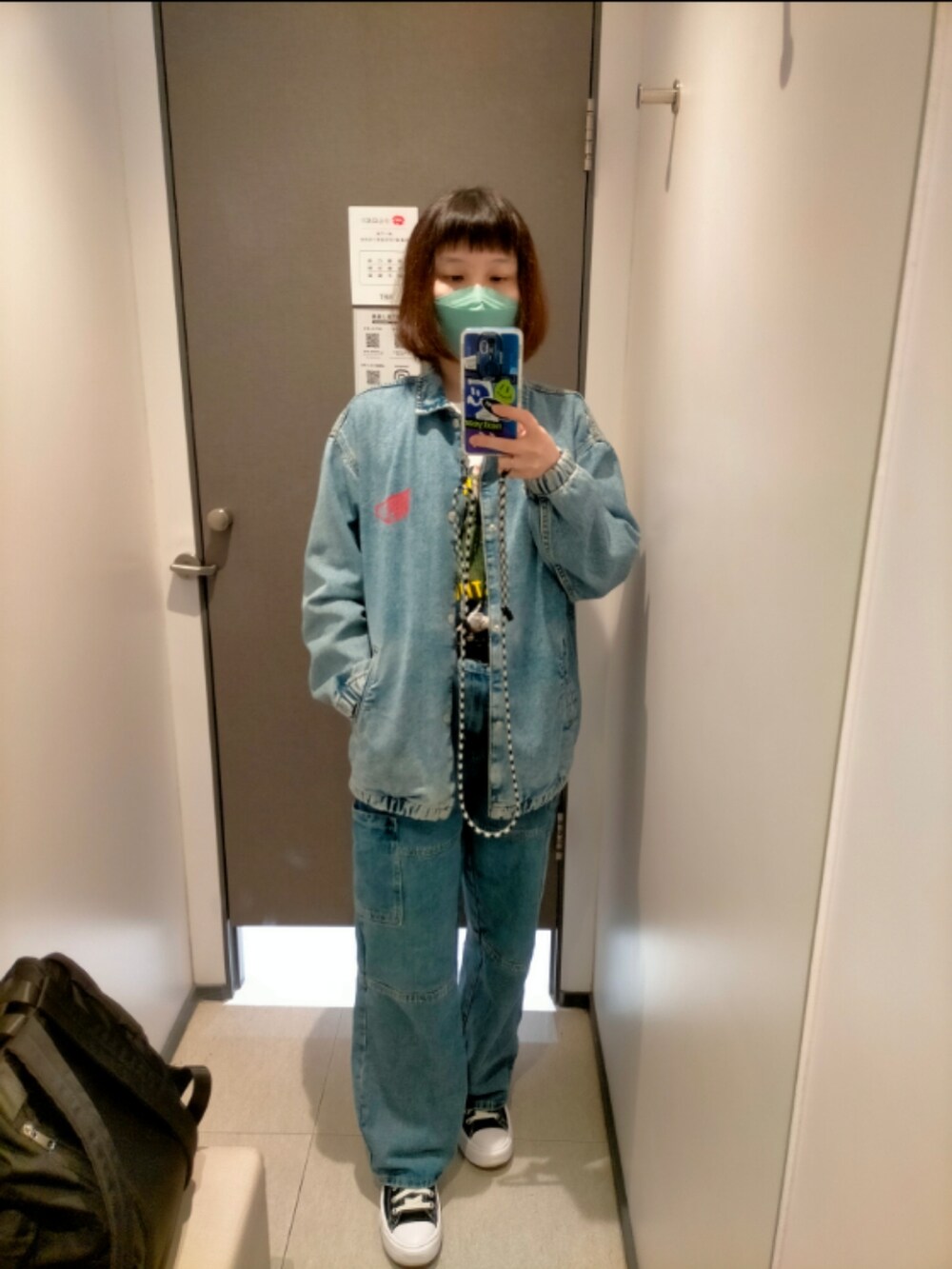 ブルー系のデニムパンツ、ホワイト系のTシャツ/カットソー、ブラック系のスニーカーを着用したレディースの春コーディネートの2枚目の写真