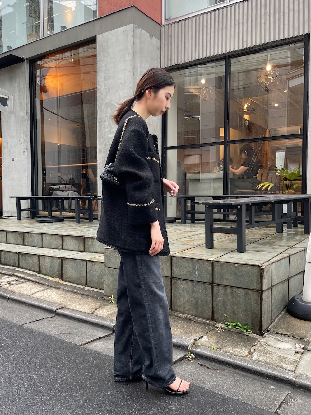 ブラック系のデニムパンツ、ブラック系のニット/セーター、ブラック系のノーカラージャケットを着用したレディースの夏コーディネートの3枚目の写真