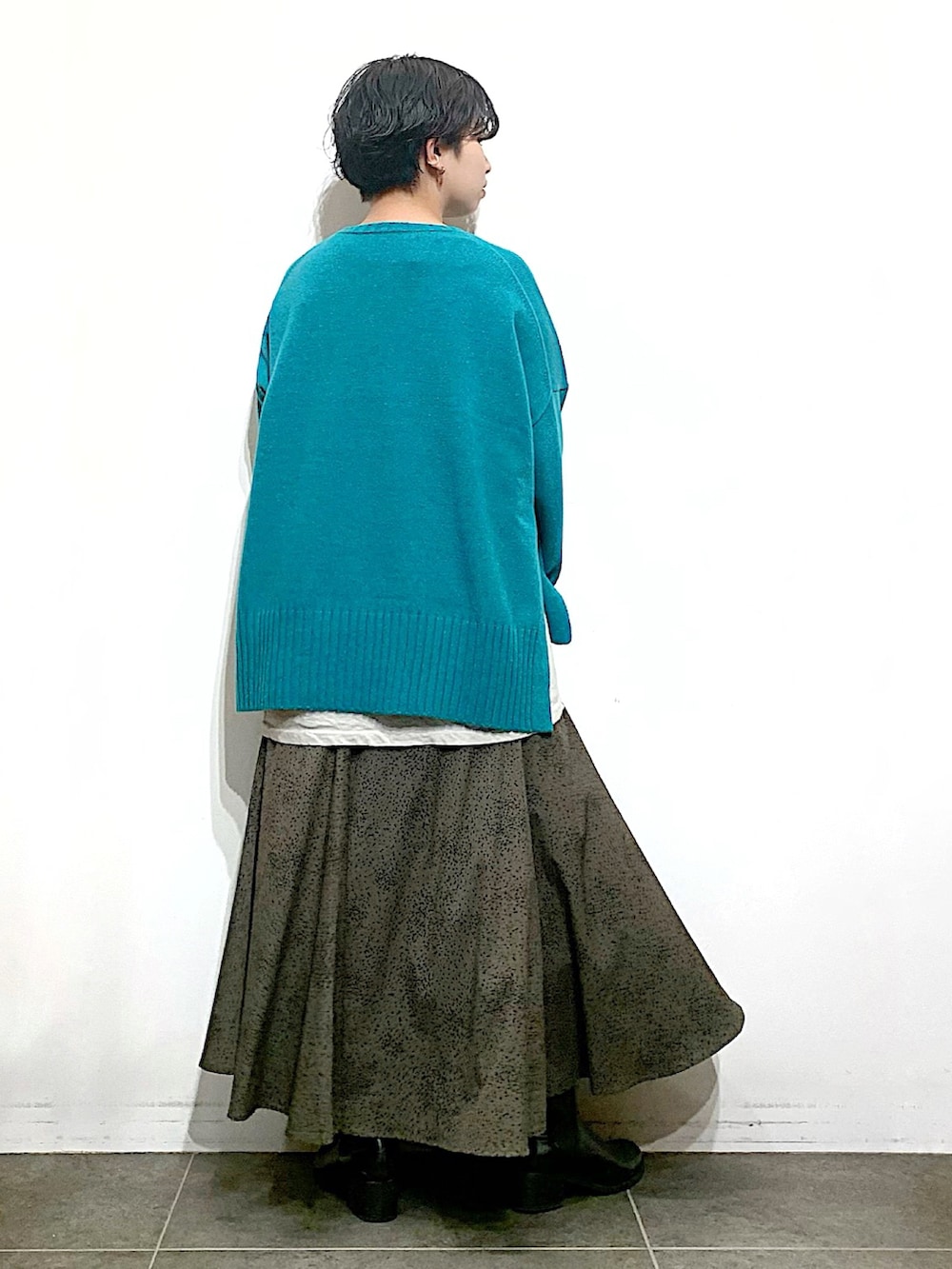 ブラック系のブーツ、グレー系のスカート、グリーン系のニット/セーターを着用したレディースの秋コーディネートの3枚目の写真