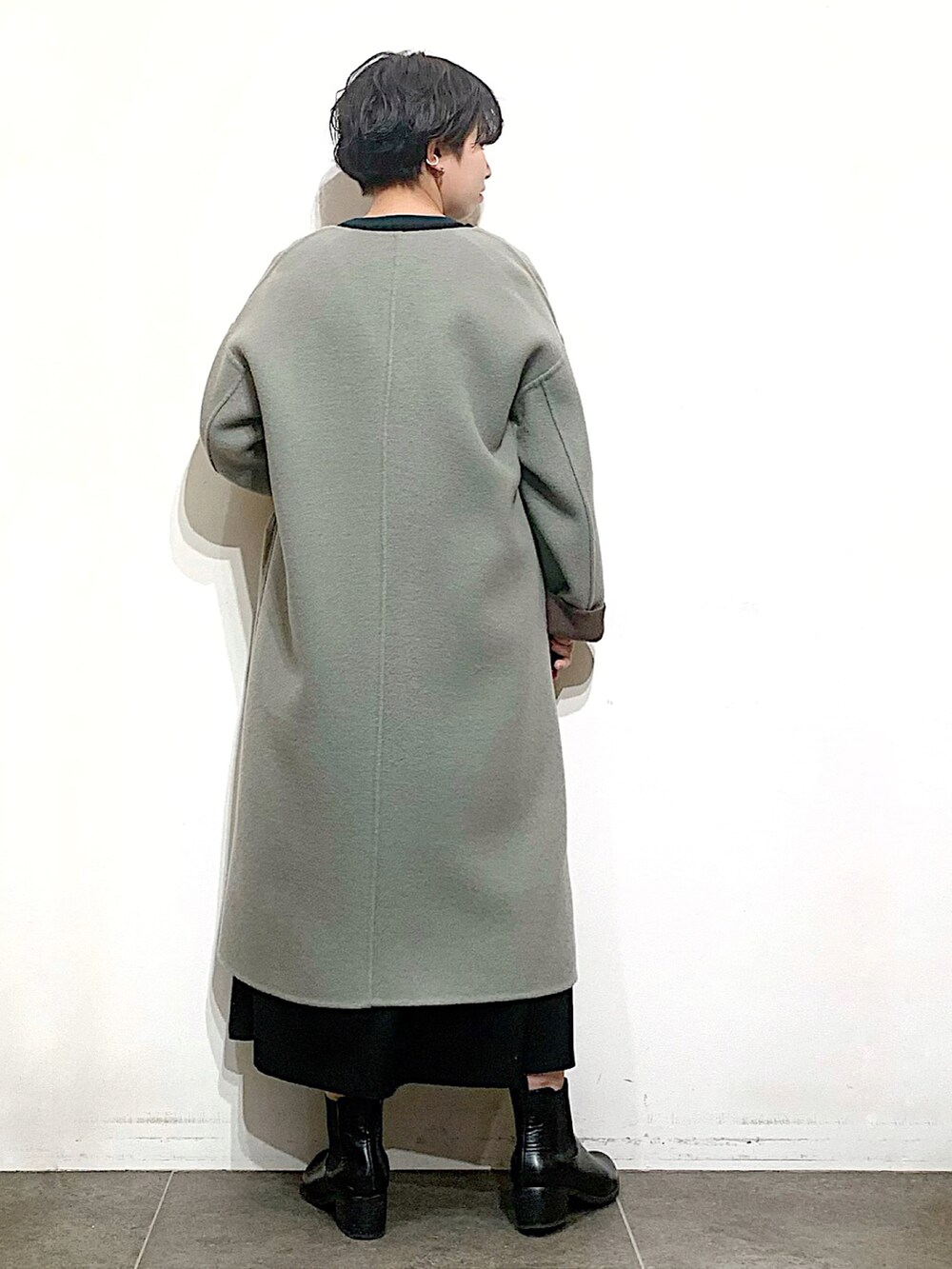 ブラック系のブーツ、ブラック系のニット/セーター、ブラウン系のノーカラージャケットを着用したレディースの秋コーディネートの2枚目の写真