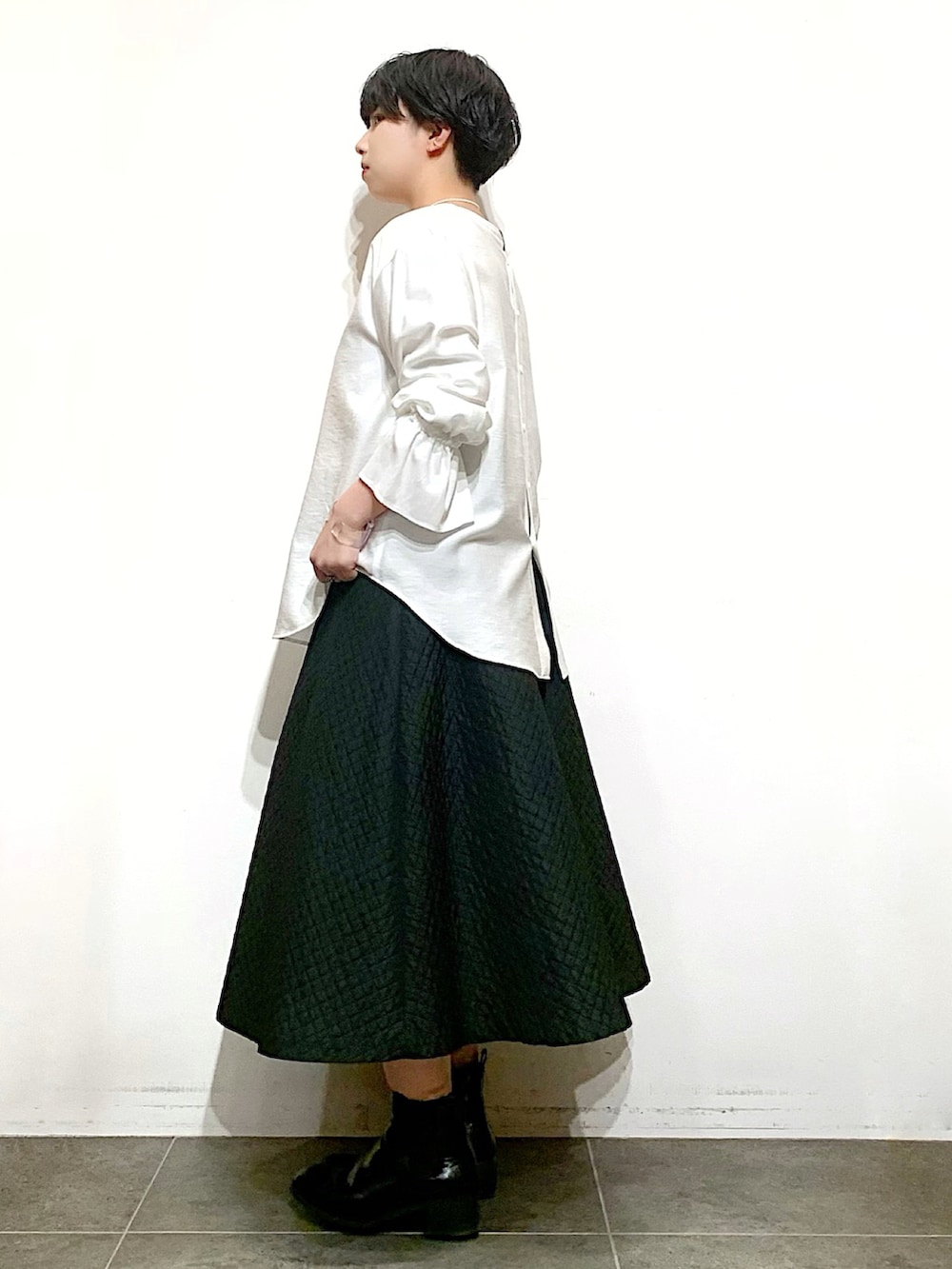 ブラック系のブーツ、ブラック系のスカート、ホワイト系のシャツ/ブラウスを着用したレディースの冬コーディネートの3枚目の写真