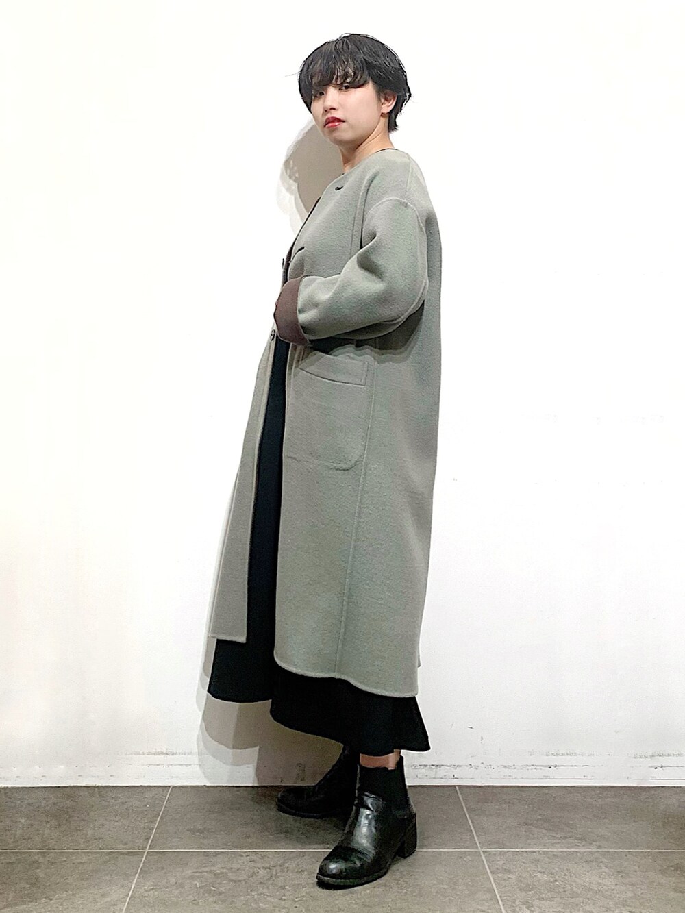 ブラック系のブーツ、ブラック系のニット/セーター、ブラウン系のノーカラージャケットを着用したレディースの秋コーディネートの3枚目の写真