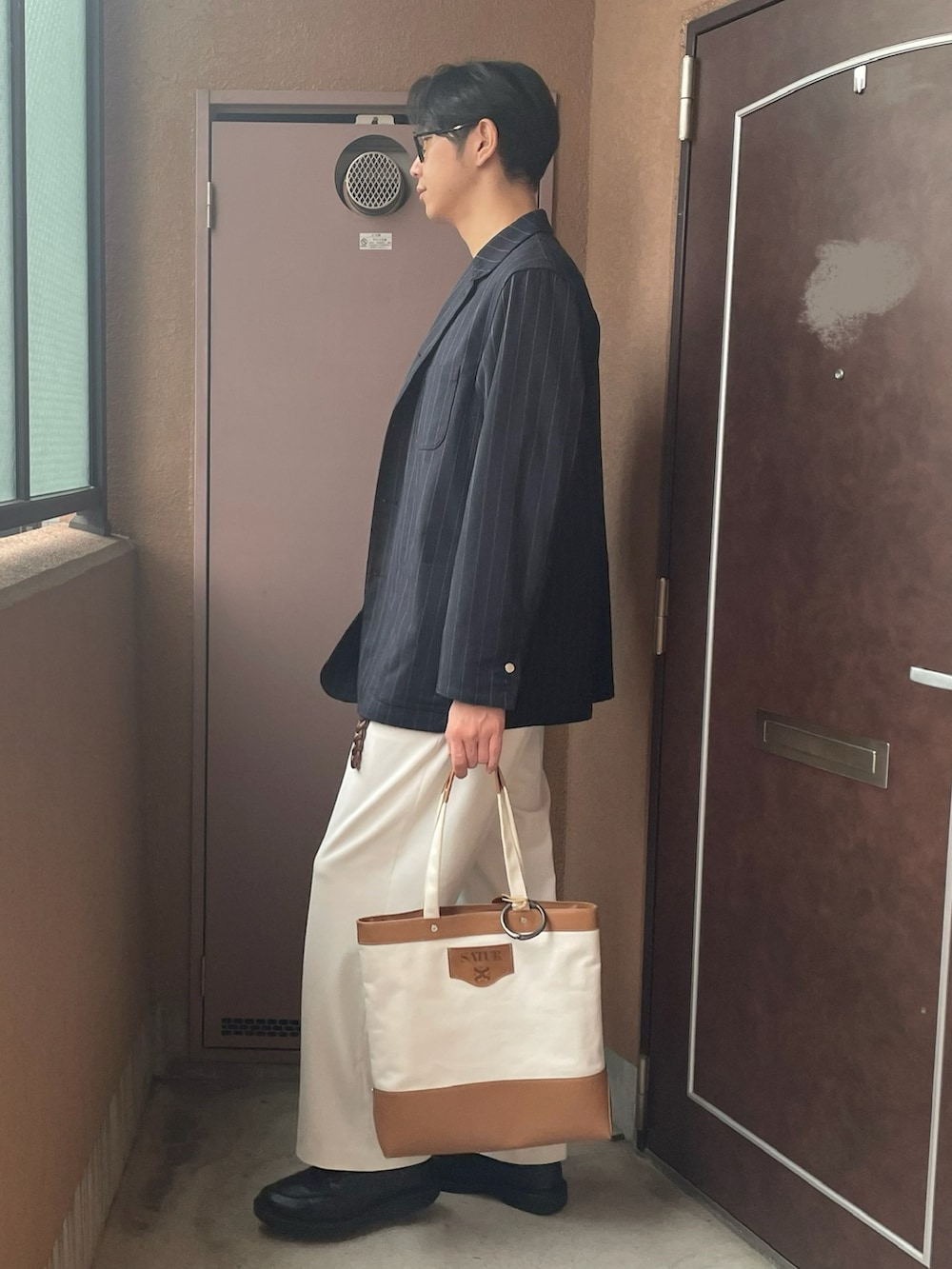 ホワイト系のTシャツ/カットソー、ブルー系のカバーオール、ホワイト系のスラックスを着用したメンズの秋コーディネートの2枚目の写真