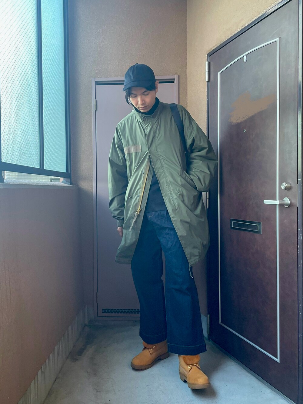 「ロングコート、冬アウター、M-65、モッズコート、カーキ、デニム、ブーツ、ミリタリー、カジュアル、キャップ、UNIQLO、ショルダーバッグ、モックネック、レイヤードスタイル、オトナカジュアル」｜「MBのアイテム（デニムパンツ、ブルー系）」を使った、MKさん（メンズ・185cm）の冬コーディネートの2枚目の写真