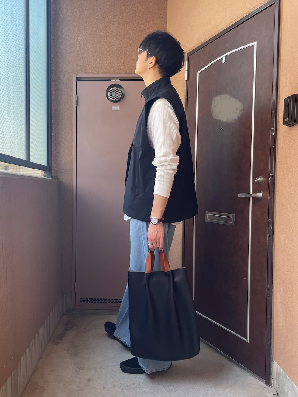 「ベスト、着回しコーデ、デニム、ヘンリーネック、Tシャツ、スリッポン、トートバッグ、UNIQLO、カジュアル、レイヤードスタイル、ワイドパンツ、プチプラ、メンズファッション、春」｜「OPENINGACTのアイテム（ベスト、ブラック系）」を使った、MKさん（メンズ・185cm）の春コーディネートの4枚目の写真