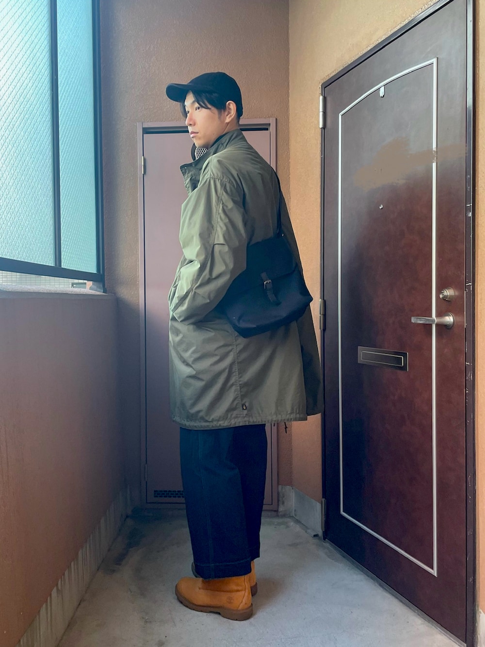 「ロングコート、冬アウター、M-65、モッズコート、カーキ、デニム、ブーツ、ミリタリー、カジュアル、キャップ、UNIQLO、ショルダーバッグ、モックネック、レイヤードスタイル、オトナカジュアル」｜「MBのアイテム（デニムパンツ、ブルー系）」を使った、MKさん（メンズ・185cm）の冬コーディネートの4枚目の写真