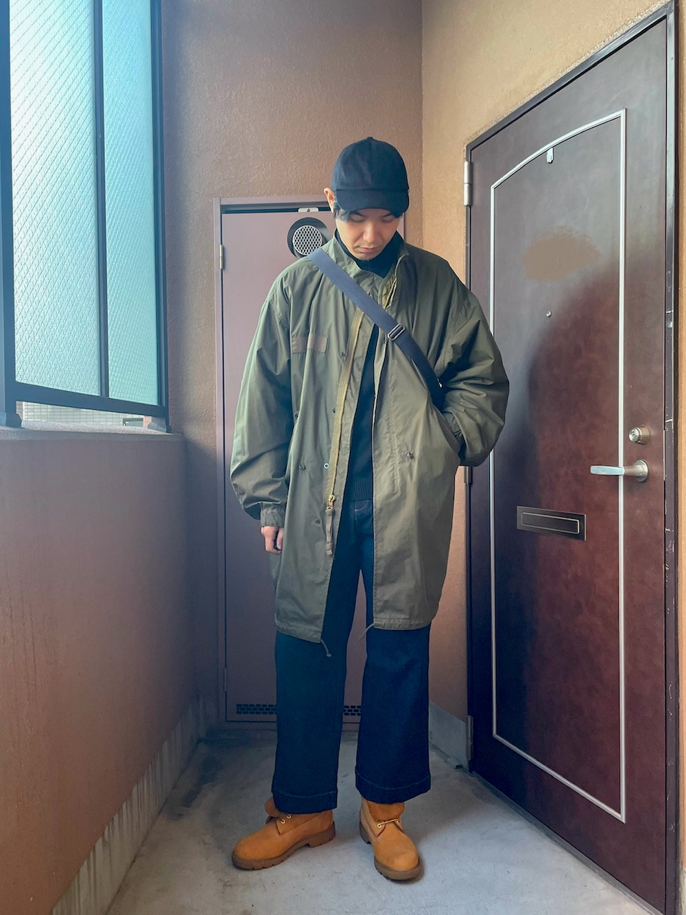 「ロングコート、冬アウター、M-65、モッズコート、カーキ、デニム、ブーツ、ミリタリー、カジュアル、キャップ、UNIQLO、ショルダーバッグ、モックネック、レイヤードスタイル、オトナカジュアル」｜「MBのアイテム（デニムパンツ、ブルー系）」を使った、MKさん（メンズ・185cm）の冬コーディネートの3枚目の写真
