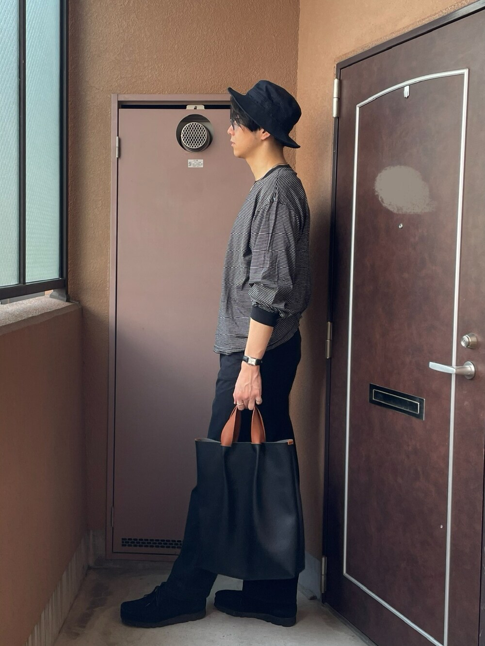 ブラック系のトートバッグ、ブラック系のモカシン/デッキシューズ、ブラック系のTシャツ/カットソーを着用したメンズの夏コーディネートの3枚目の写真