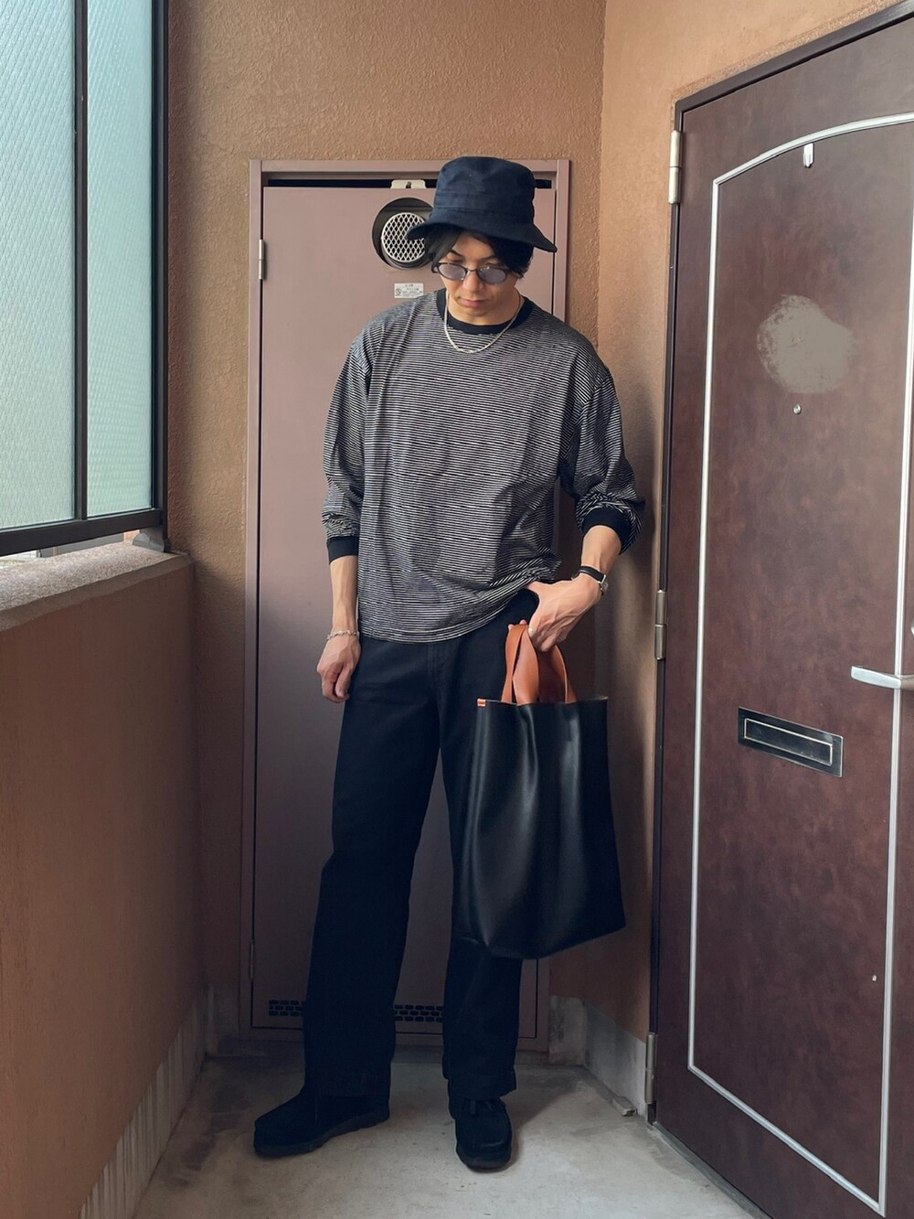 ブラック系のトートバッグ、ブラック系のモカシン/デッキシューズ、ブラック系のTシャツ/カットソーを着用したメンズの夏コーディネートの2枚目の写真