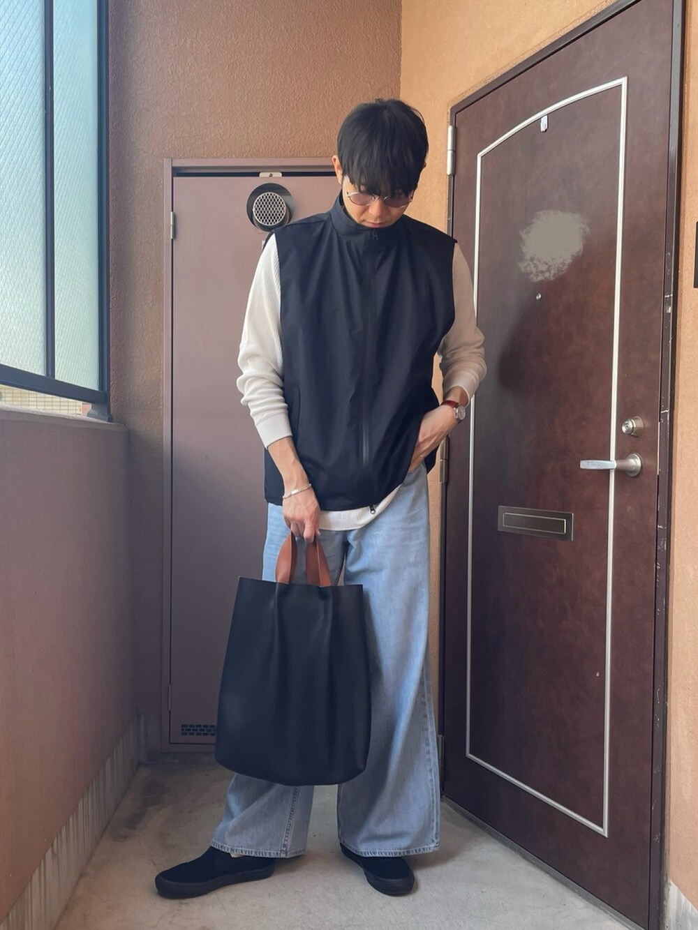 「ベスト、着回しコーデ、デニム、ヘンリーネック、Tシャツ、スリッポン、トートバッグ、UNIQLO、カジュアル、レイヤードスタイル、ワイドパンツ、プチプラ、メンズファッション、春」｜「OPENINGACTのアイテム（ベスト、ブラック系）」を使った、MKさん（メンズ・185cm）の春コーディネートの3枚目の写真