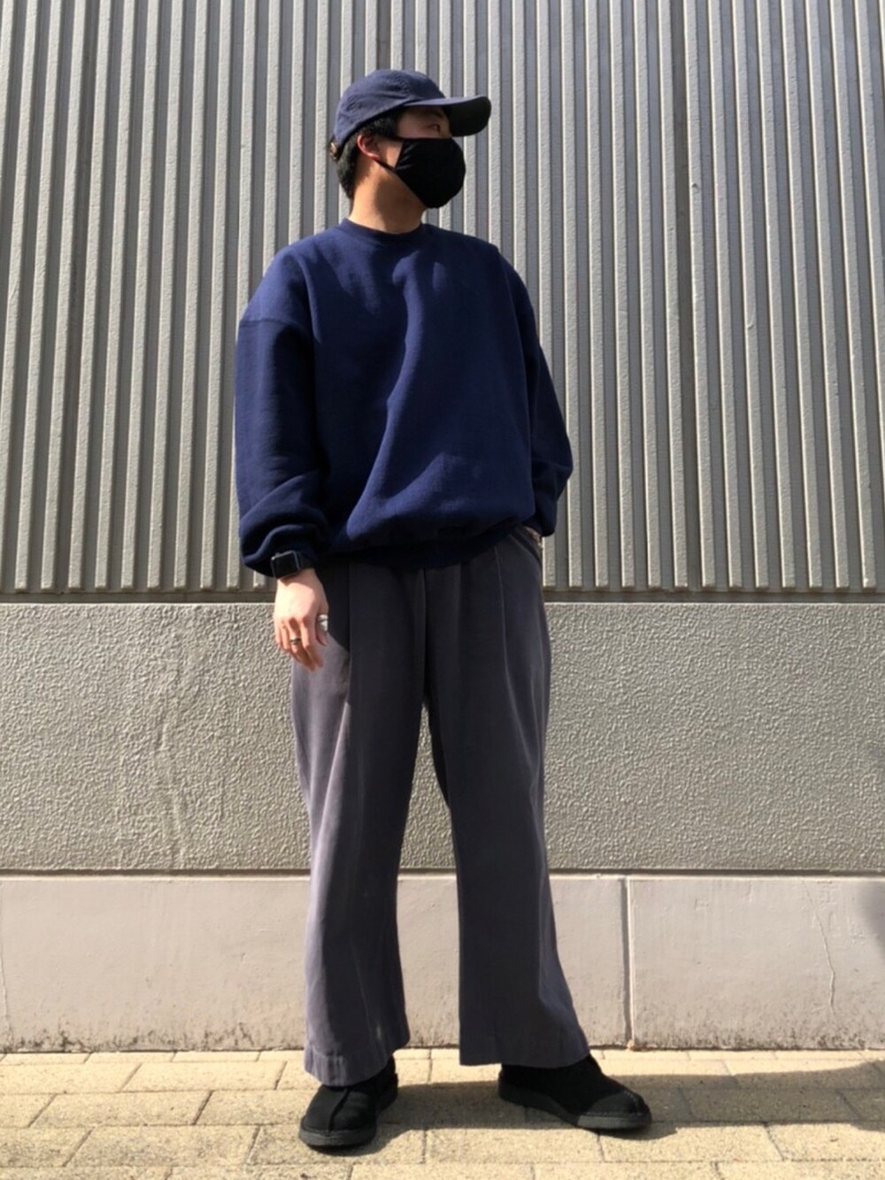ブラック系のブーツ、グレー系のチノパンツ、ブルー系のスウェットを着用したメンズの春コーディネートの2枚目の写真