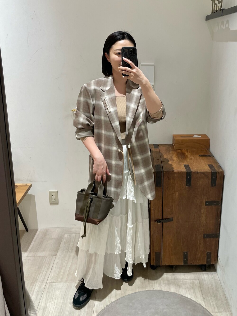 ベージュ系のニット/セーター、ブラウン系のトートバッグ、ブラック系のスニーカーを着用したレディースの春コーディネートの9枚目の写真