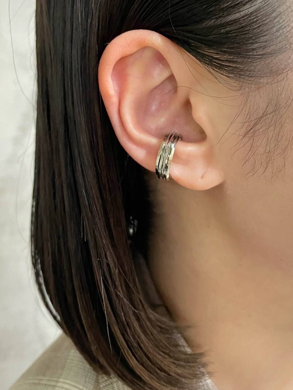 ベージュ系のニット/セーター、ブラウン系のトートバッグ、ブラック系のスニーカーを着用したレディースの春コーディネートの7枚目の写真