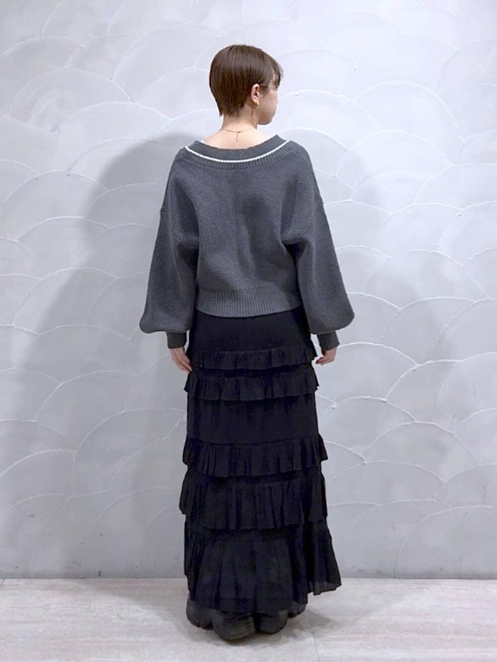 ホワイト系のTシャツ/カットソー、グレー系のカーディガン/ボレロ、ブラック系のローファーを着用したレディースの冬コーディネートの5枚目の写真