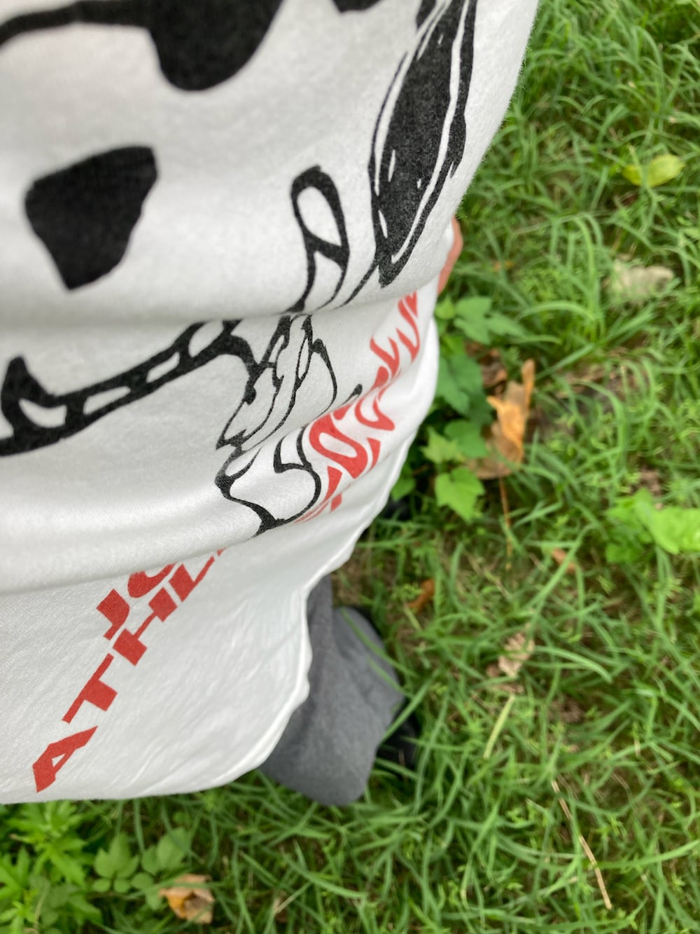 ホワイト系のTシャツ/カットソー、グレー系のパンツ、ブラック系のブーツを着用したメンズの秋コーディネートの2枚目の写真