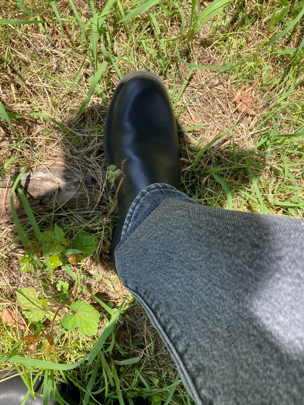 ブラック系のデニムパンツ、ブラック系のブーツ、ホワイト系のTシャツ/カットソーを着用したメンズの夏コーディネートの3枚目の写真