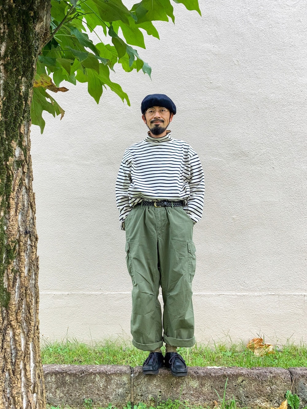 ホワイト系のTシャツ/カットソー、グリーン系のカーゴパンツ、ブラック系のモカシン/デッキシューズを着用したメンズの秋コーディネートの2枚目の写真