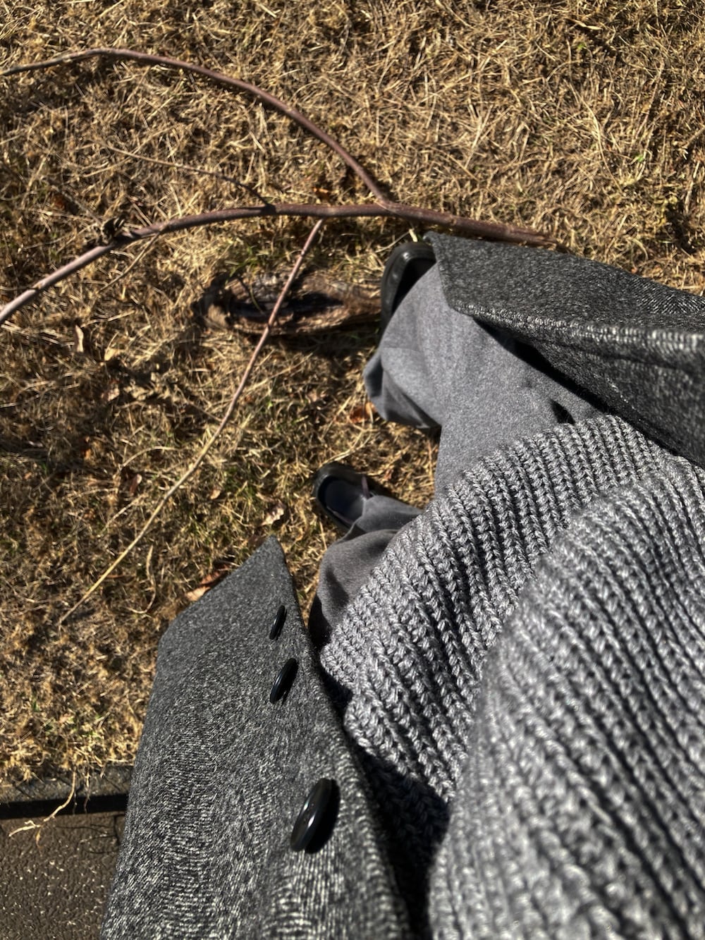 ホワイト系のTシャツ/カットソー、グレー系のニット/セーター、グレー系のステンカラーコートを着用したメンズの冬コーディネートの2枚目の写真