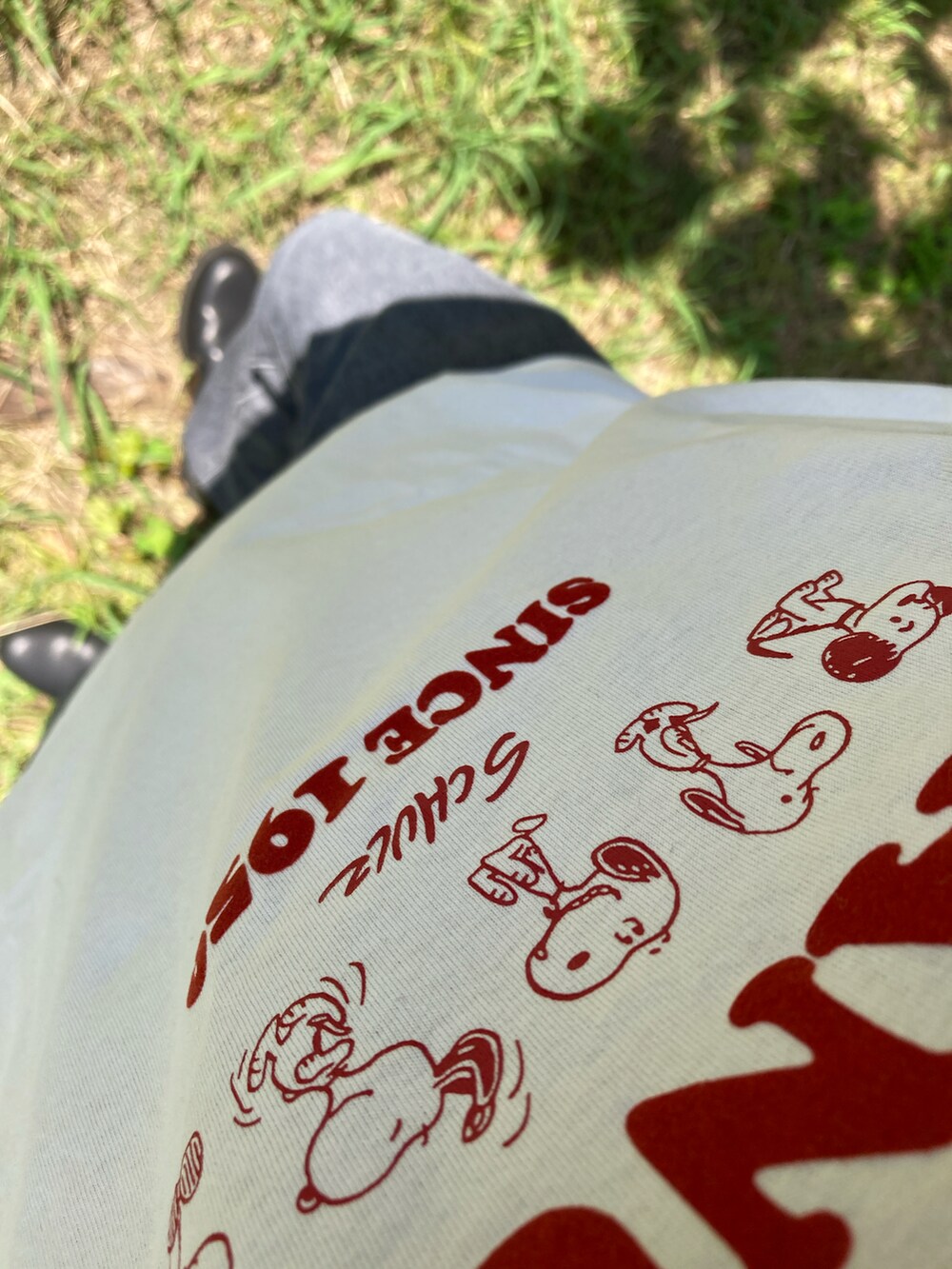 ブラック系のデニムパンツ、ブラック系のブーツ、ホワイト系のTシャツ/カットソーを着用したメンズの夏コーディネートの2枚目の写真