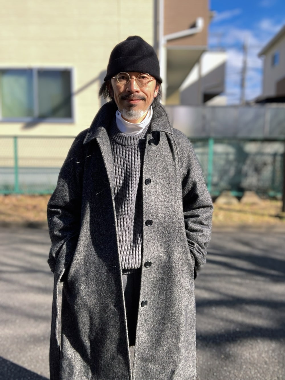 ホワイト系のTシャツ/カットソー、グレー系のニット/セーター、グレー系のステンカラーコートを着用したメンズの冬コーディネートの4枚目の写真