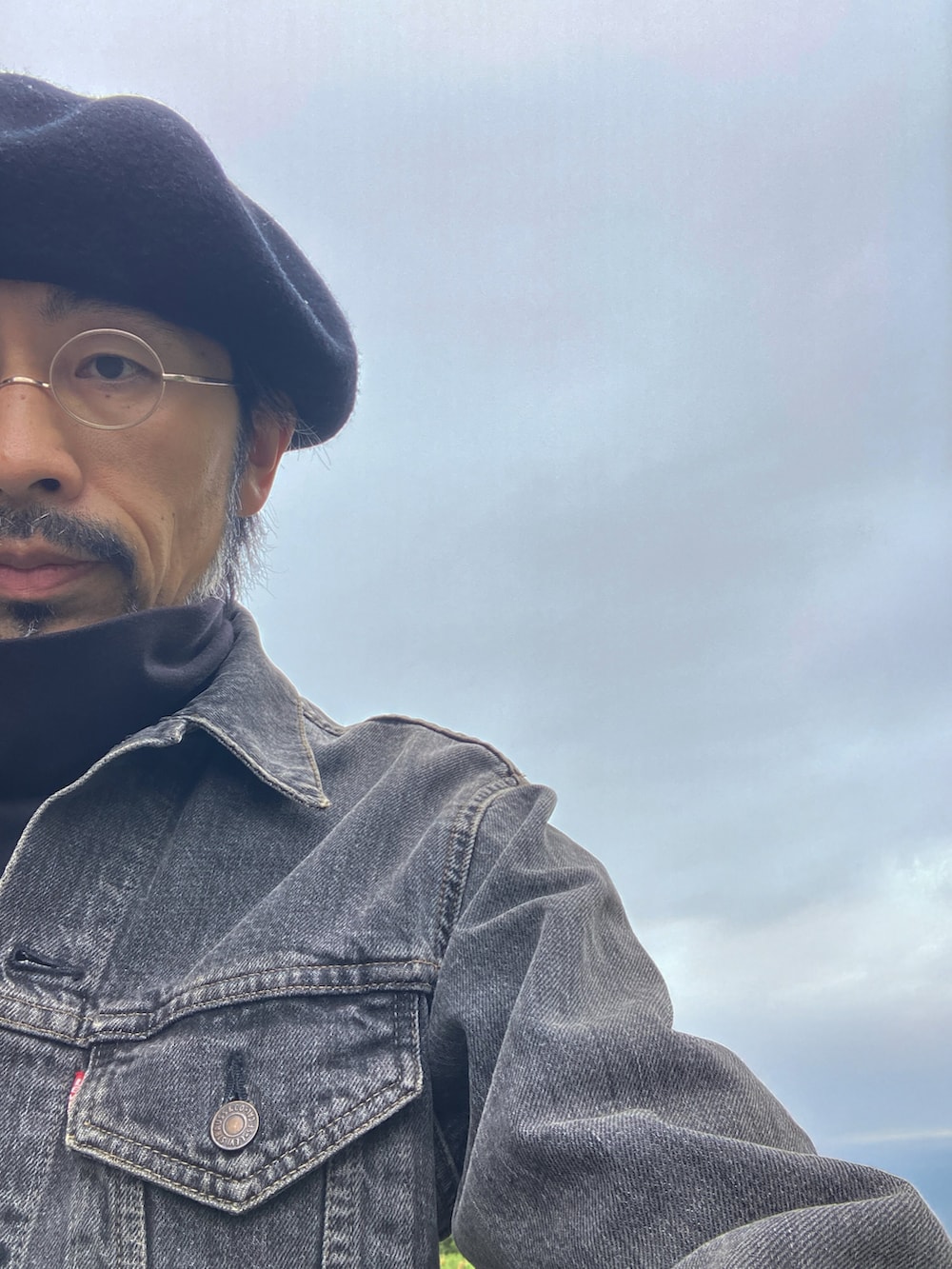 ブラック系のデニムジャケット、ブラック系のTシャツ/カットソー、ブラック系のチノパンツを着用したメンズの秋コーディネートの4枚目の写真