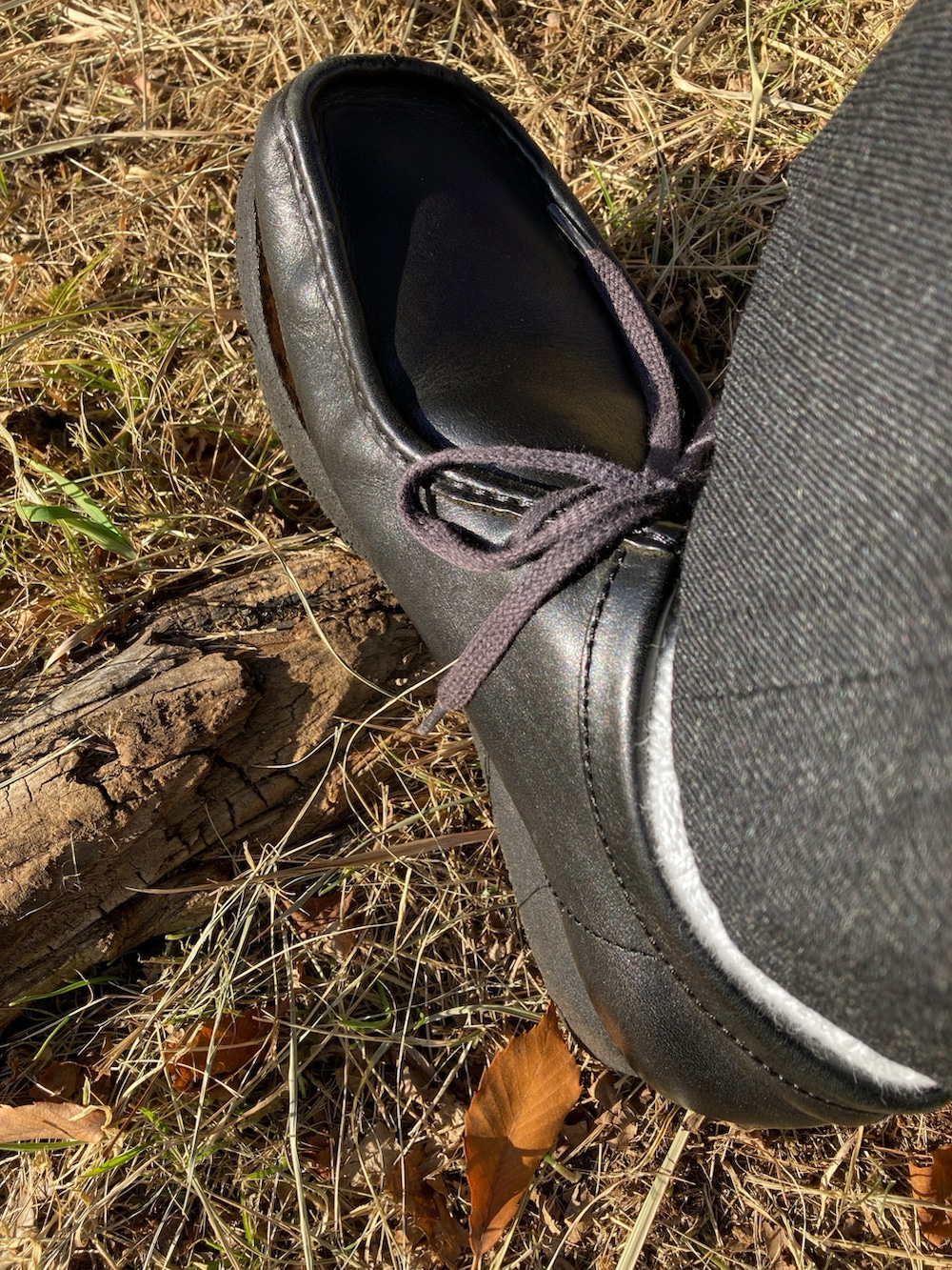 グリーン系のステンカラーコート、ブラック系のTシャツ/カットソー、ブラック系のデニムジャケットを着用したメンズの冬コーディネートの4枚目の写真