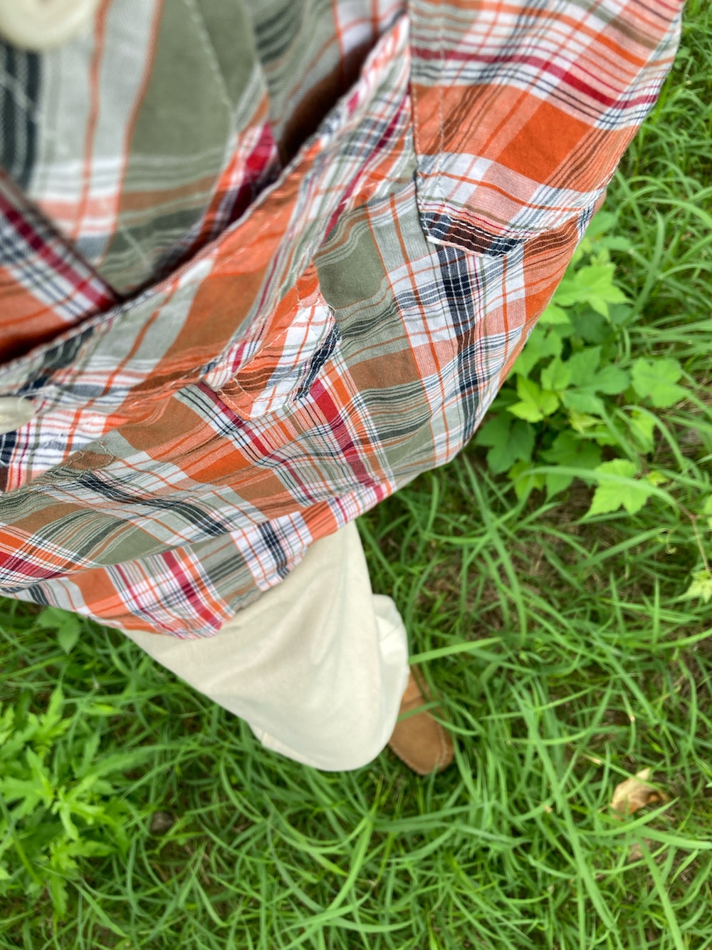 オレンジ系のシャツ/ブラウス、ホワイト系のデニムパンツ、ベージュ系のモカシン/デッキシューズを着用したメンズの夏コーディネートの2枚目の写真