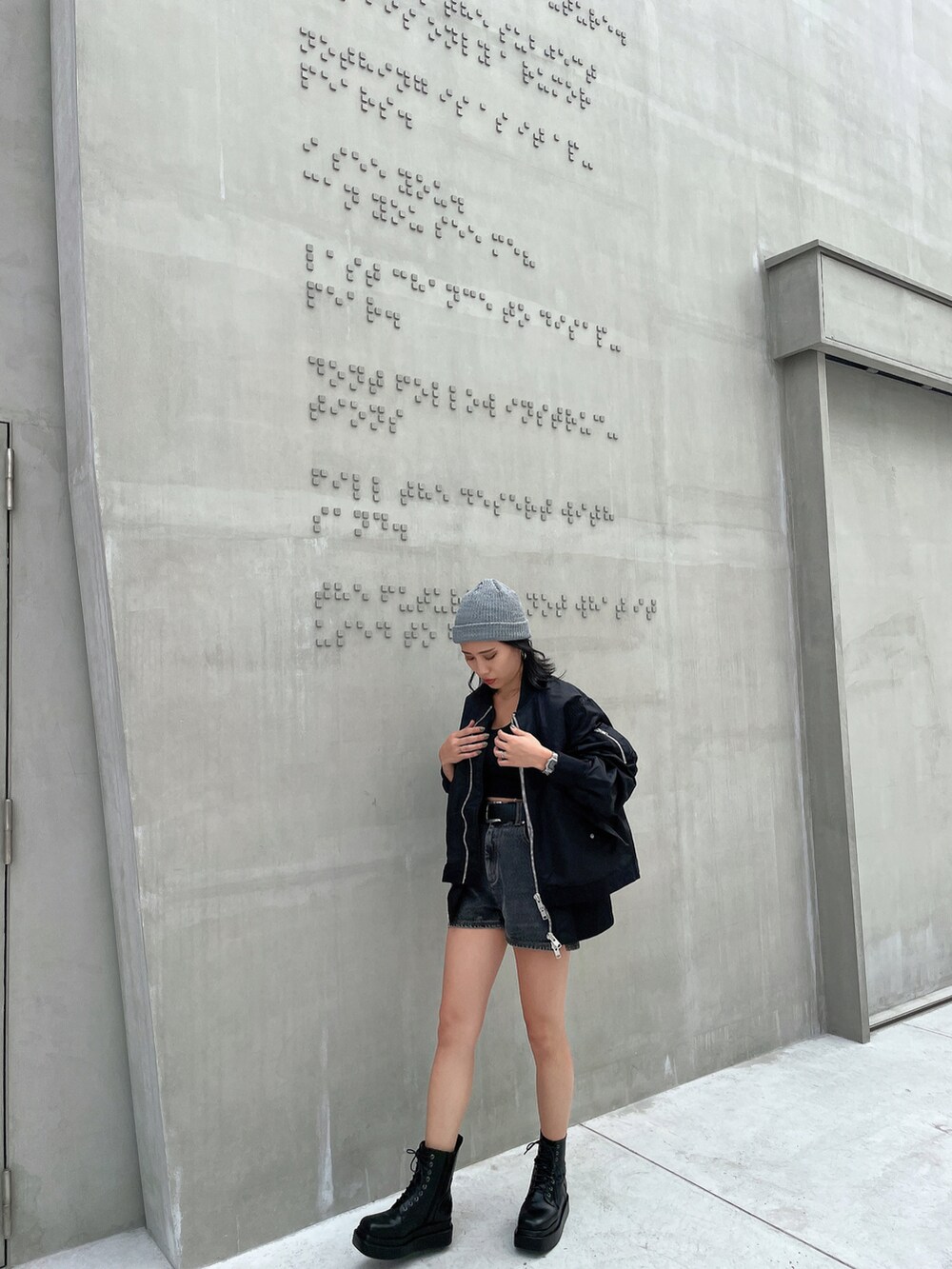 ホワイト系のキャミソール、ブラック系のMA-1、ブラック系のデニムパンツを着用したレディースの秋コーディネートの2枚目の写真