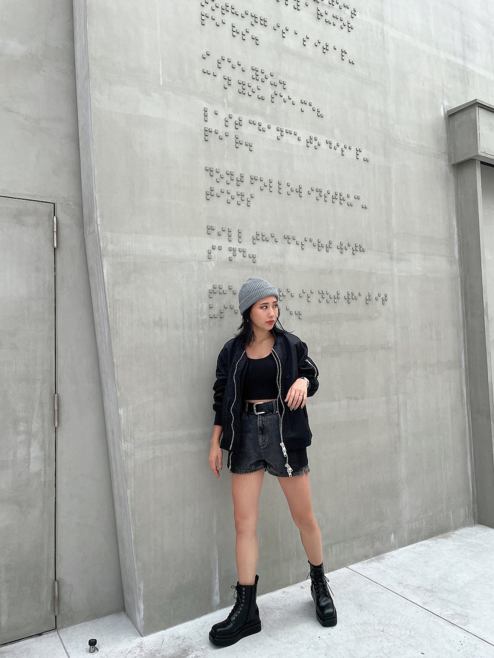 ホワイト系のキャミソール、ブラック系のMA-1、ブラック系のデニムパンツを着用したレディースの秋コーディネートの3枚目の写真