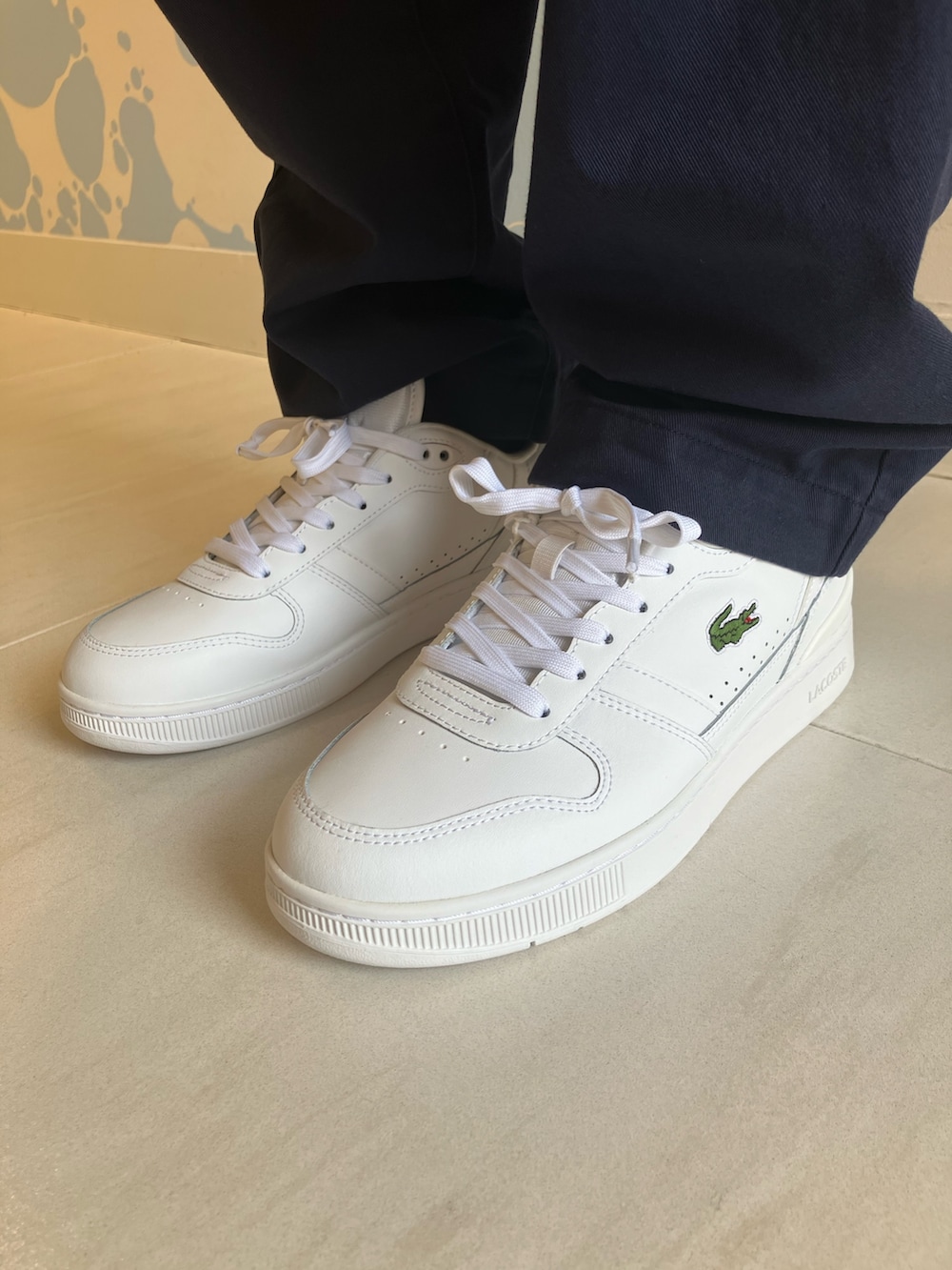 イエロー系のシャツ/ブラウス、ホワイト系のスニーカー、ブルー系のチノパンツを着用したメンズの夏コーディネートの6枚目の写真