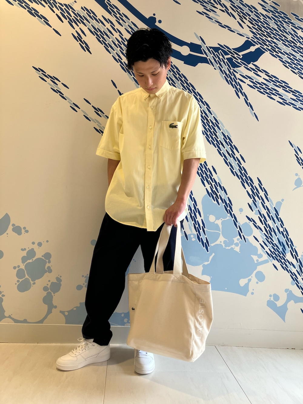 イエロー系のシャツ/ブラウス、ホワイト系のスニーカー、ブルー系のチノパンツを着用したメンズの夏コーディネートの3枚目の写真