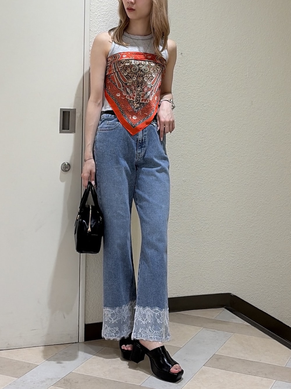 グレー系のTシャツ/カットソー、ブルー系のデニムパンツ、ブラック系のハンドバッグを着用したレディースの夏コーディネートの4枚目の写真