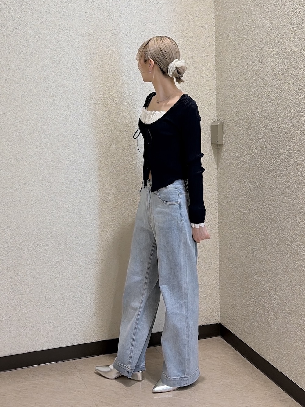 ブルー系のニット/セーター、ブルー系のデニムパンツ、シルバー系のパンプスを着用したレディースの春コーディネートの2枚目の写真