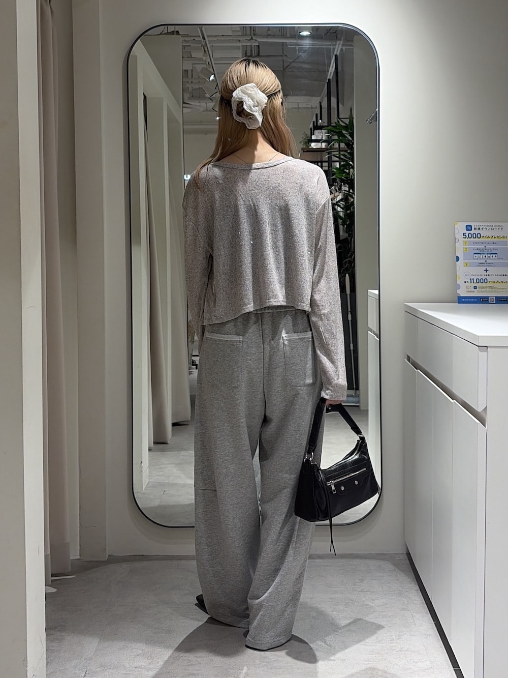 グレー系のTシャツ/カットソー、グレー系のスウェットパンツ、ブラック系のショルダーバッグを着用したレディースの秋コーディネートの3枚目の写真