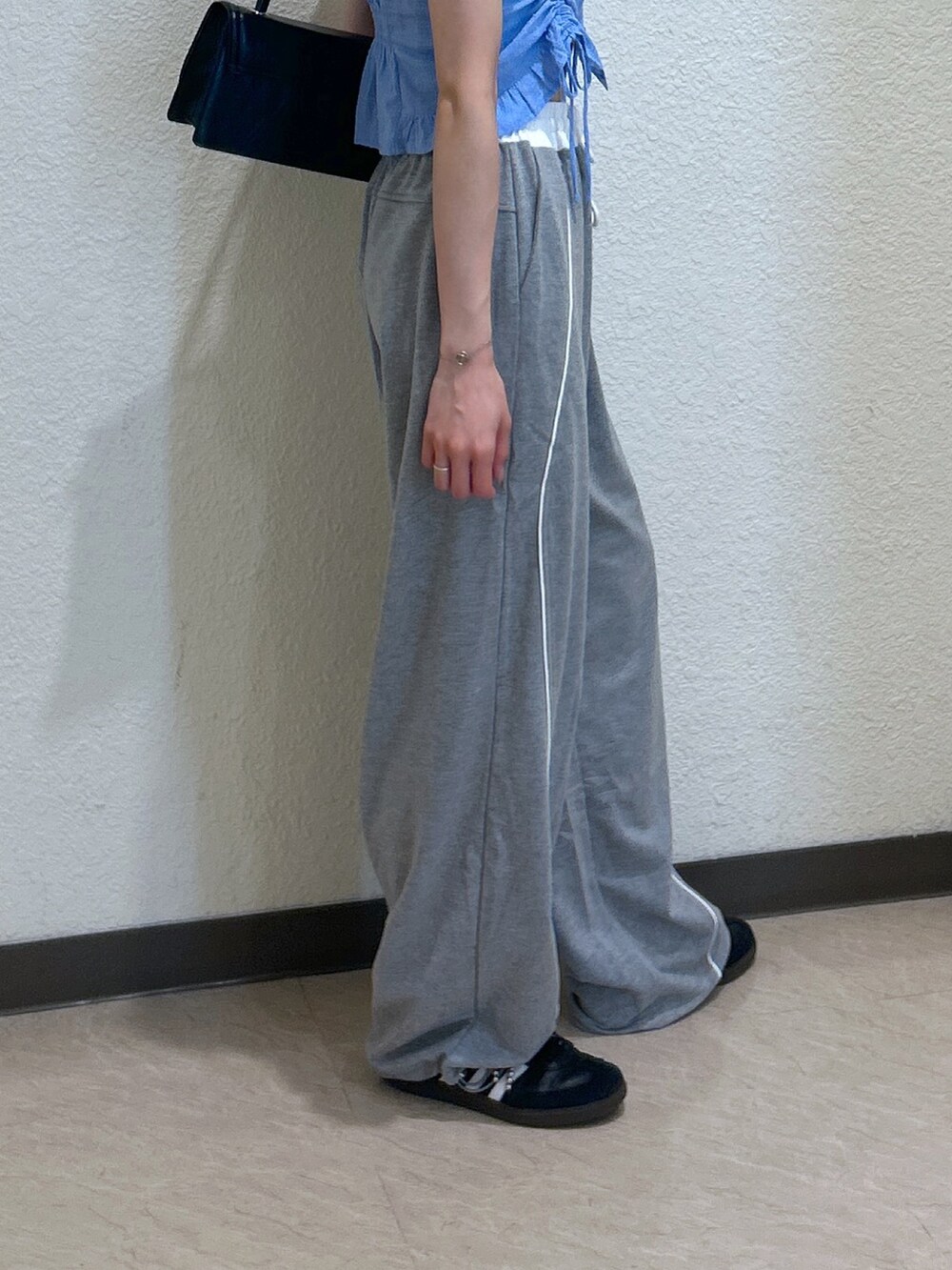 ブルー系のシャツ/ブラウス、ブラック系のショルダーバッグを着用したレディースの夏コーディネートの4枚目の写真