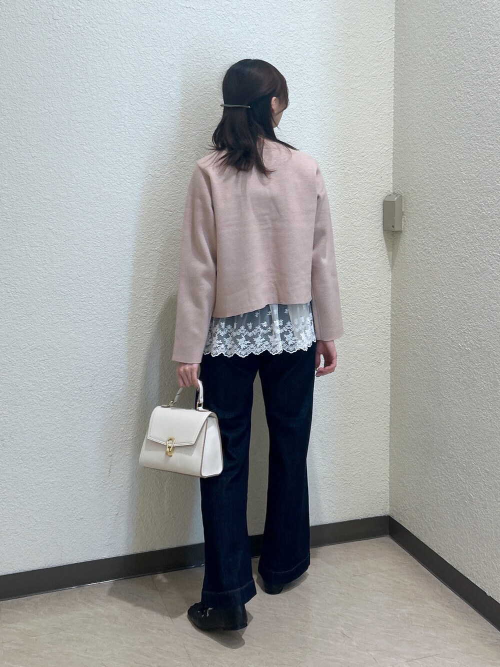 ベージュ系のニット/セーター、ブルー系のデニムパンツ、ホワイト系のトートバッグを着用したレディースの秋コーディネートの3枚目の写真