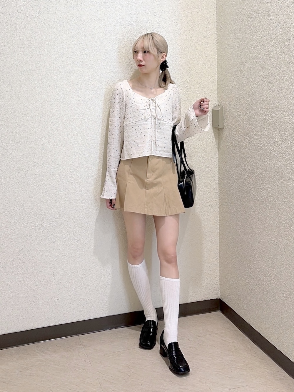 ベージュ系のスカート、ブラック系のローファー、ホワイト系のシャツ/ブラウスを着用したレディースの春コーディネートの5枚目の写真