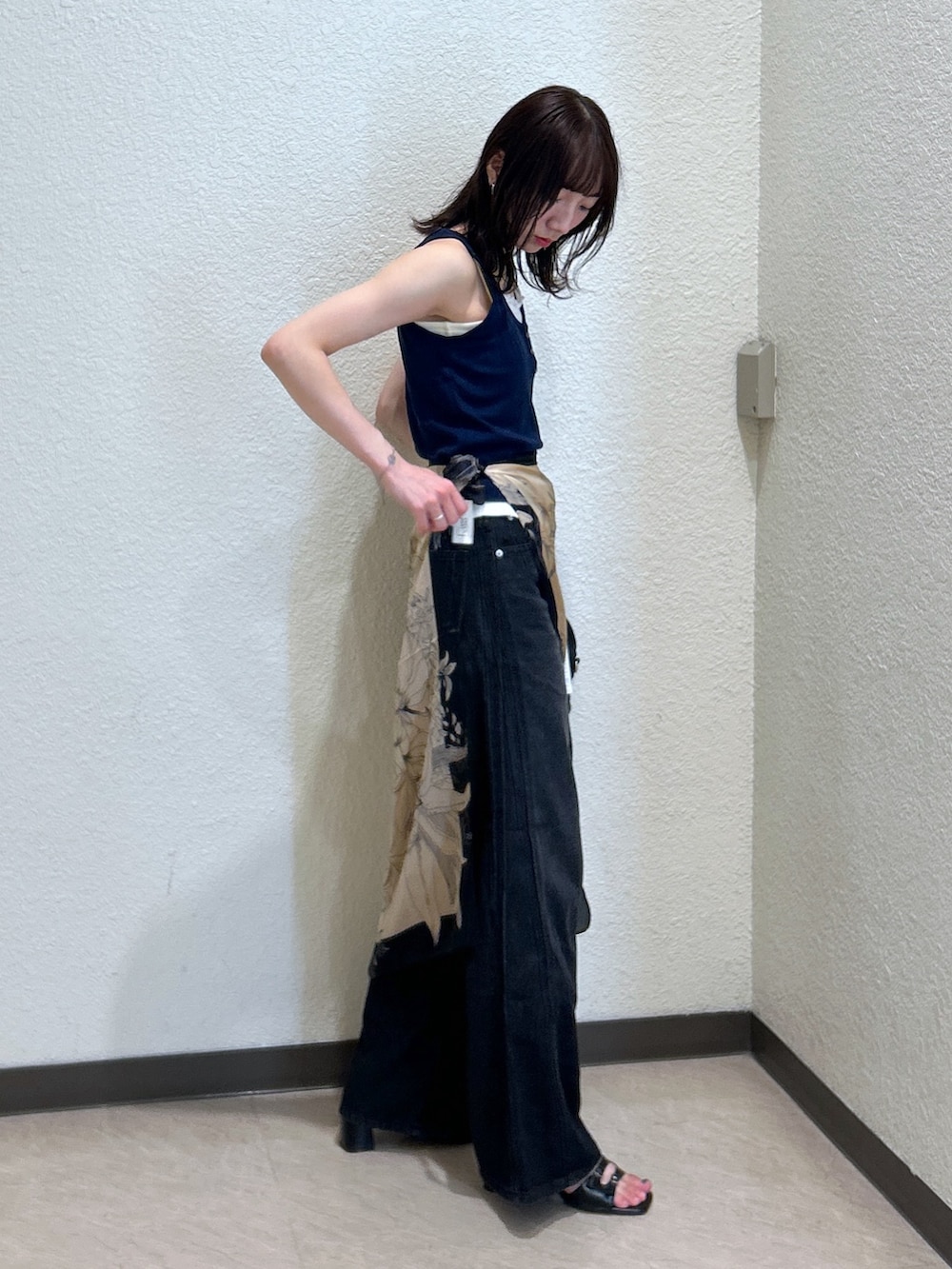 ブルー系のTシャツ/カットソー、ブラック系のデニムパンツ、ブラック系のサンダルを着用したレディースの夏コーディネートの2枚目の写真