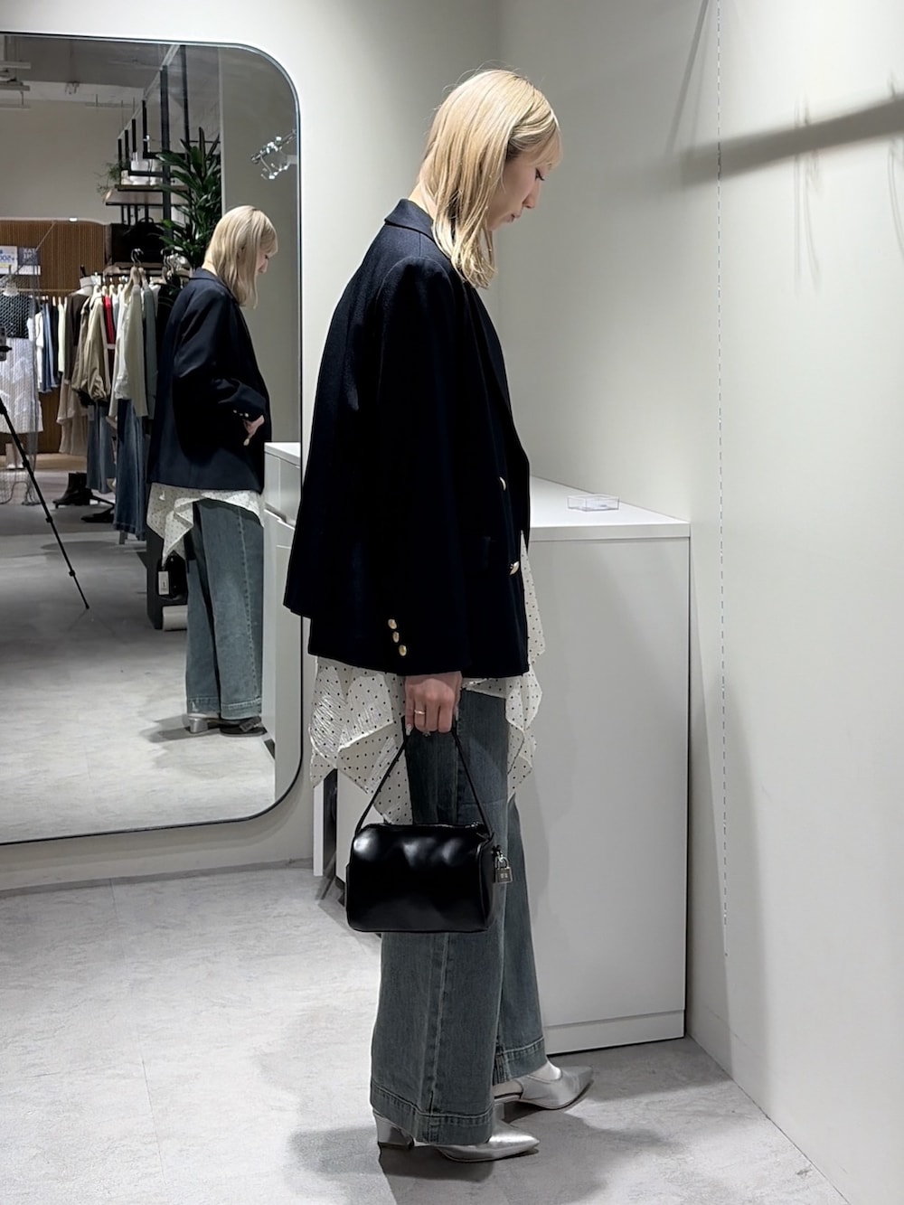 ホワイト系のワンピース、ブルー系のテーラードジャケット、ブルー系のデニムパンツを着用したレディースの春コーディネートの2枚目の写真