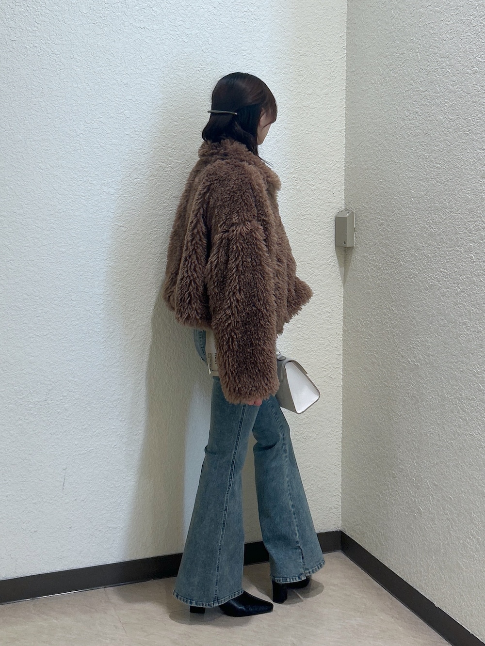 ホワイト系のトートバッグ、ブルー系のデニムパンツ、ブラック系のパンプスを着用したレディースの秋コーディネートの2枚目の写真