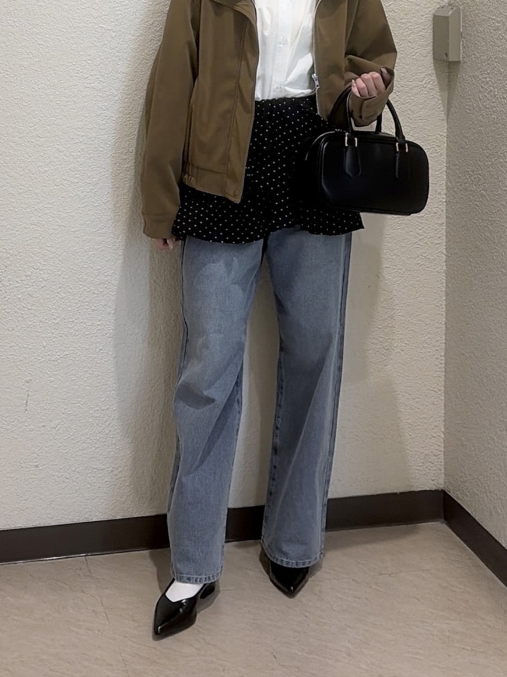 ブラック系のシャツ/ブラウス、ブラック系のハンドバッグ、ブルー系のその他パンツを着用したレディースの冬コーディネートの6枚目の写真