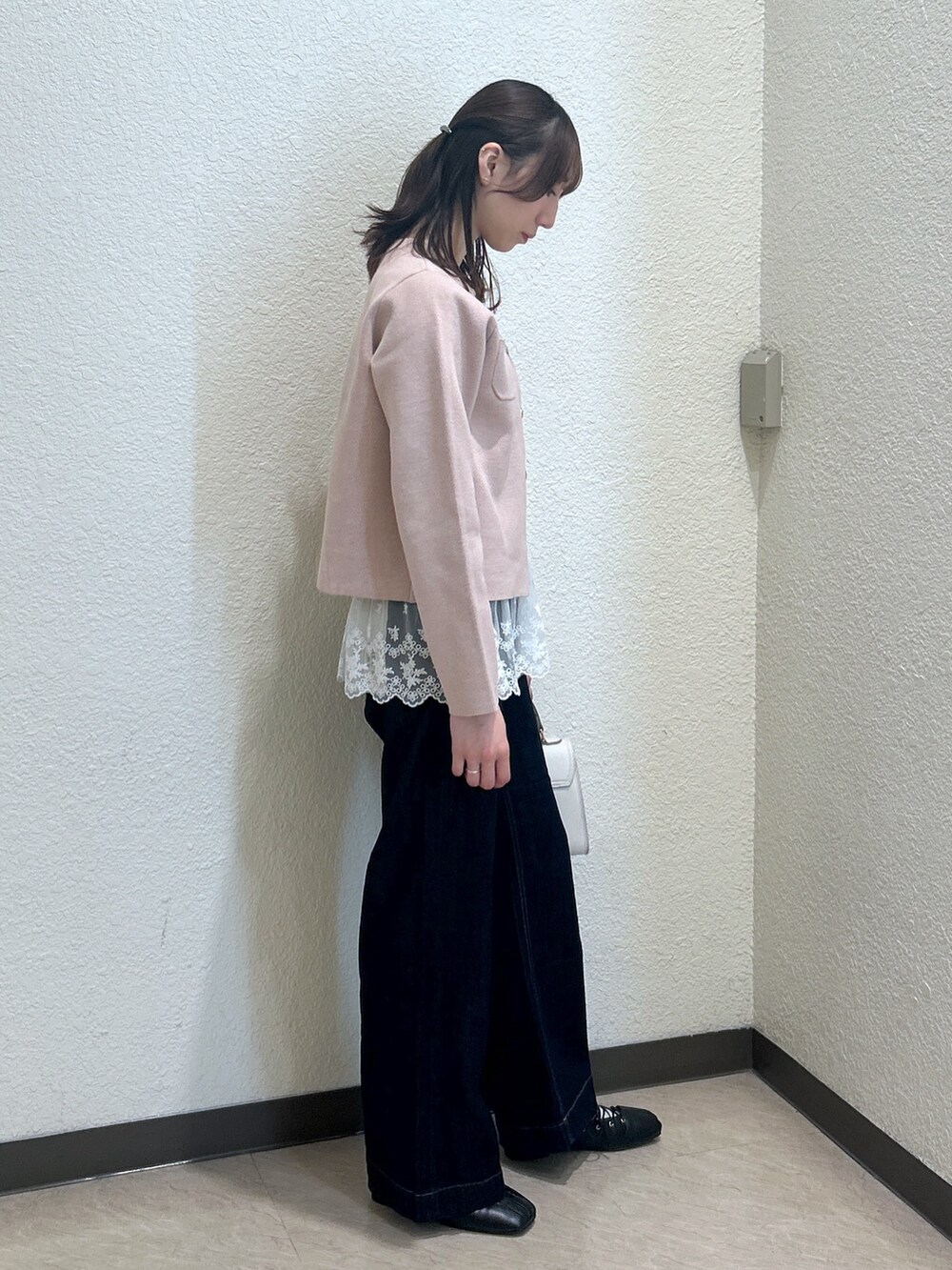 ベージュ系のニット/セーター、ブルー系のデニムパンツ、ホワイト系のトートバッグを着用したレディースの秋コーディネートの4枚目の写真