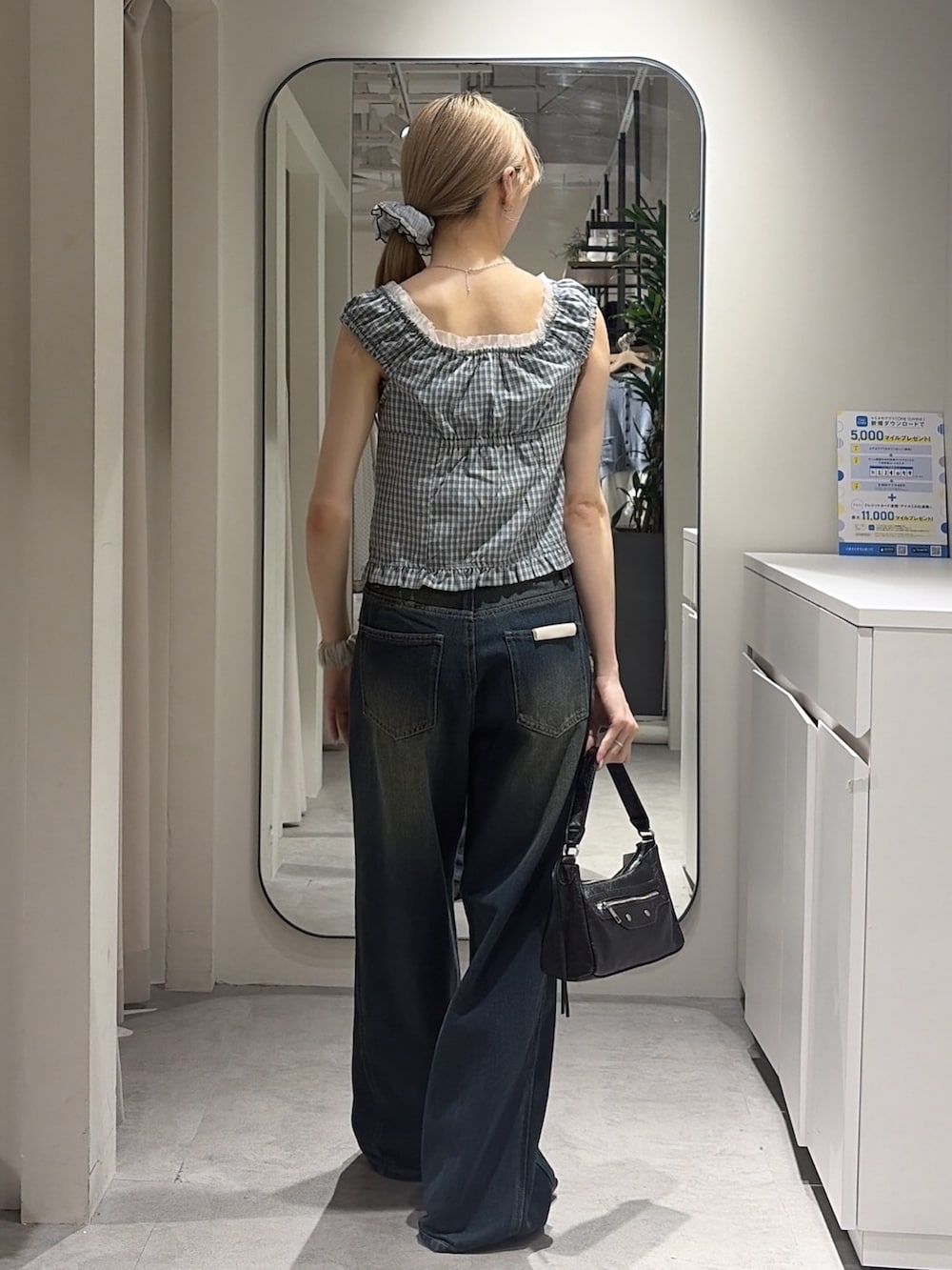 ブルー系のシャツ/ブラウス、ブルー系のデニムパンツ、ブラック系のショルダーバッグを着用したレディースの夏コーディネートの3枚目の写真