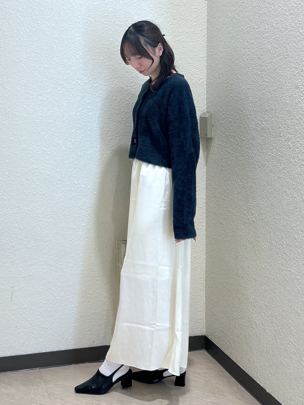 ブルー系のニット/セーター、ホワイト系のスカート、ホワイト系のトートバッグを着用したレディースの秋コーディネートの2枚目の写真