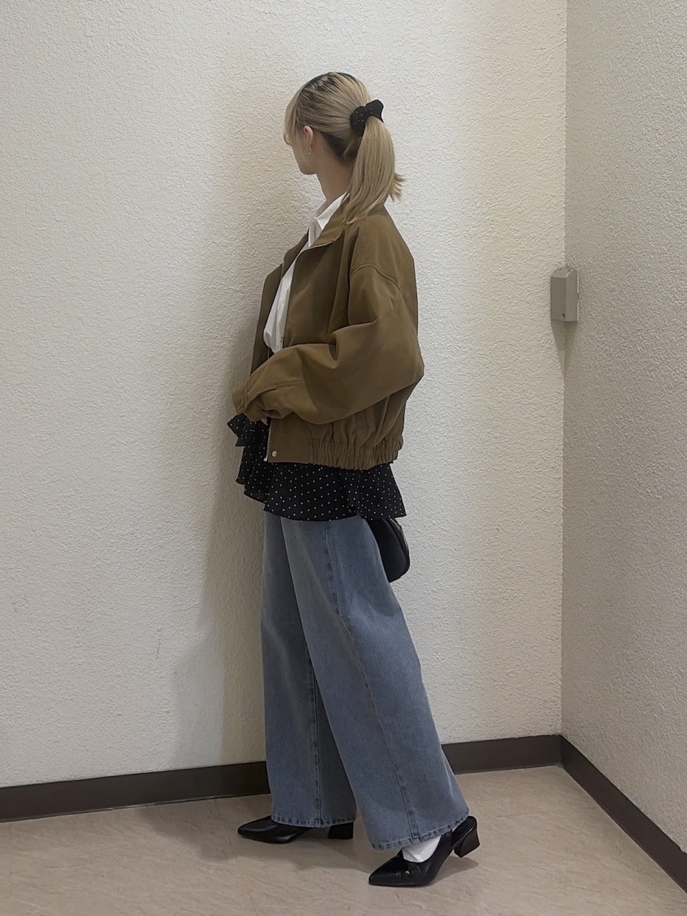 ブラック系のシャツ/ブラウス、ブラック系のハンドバッグ、ブルー系のその他パンツを着用したレディースの冬コーディネートの3枚目の写真