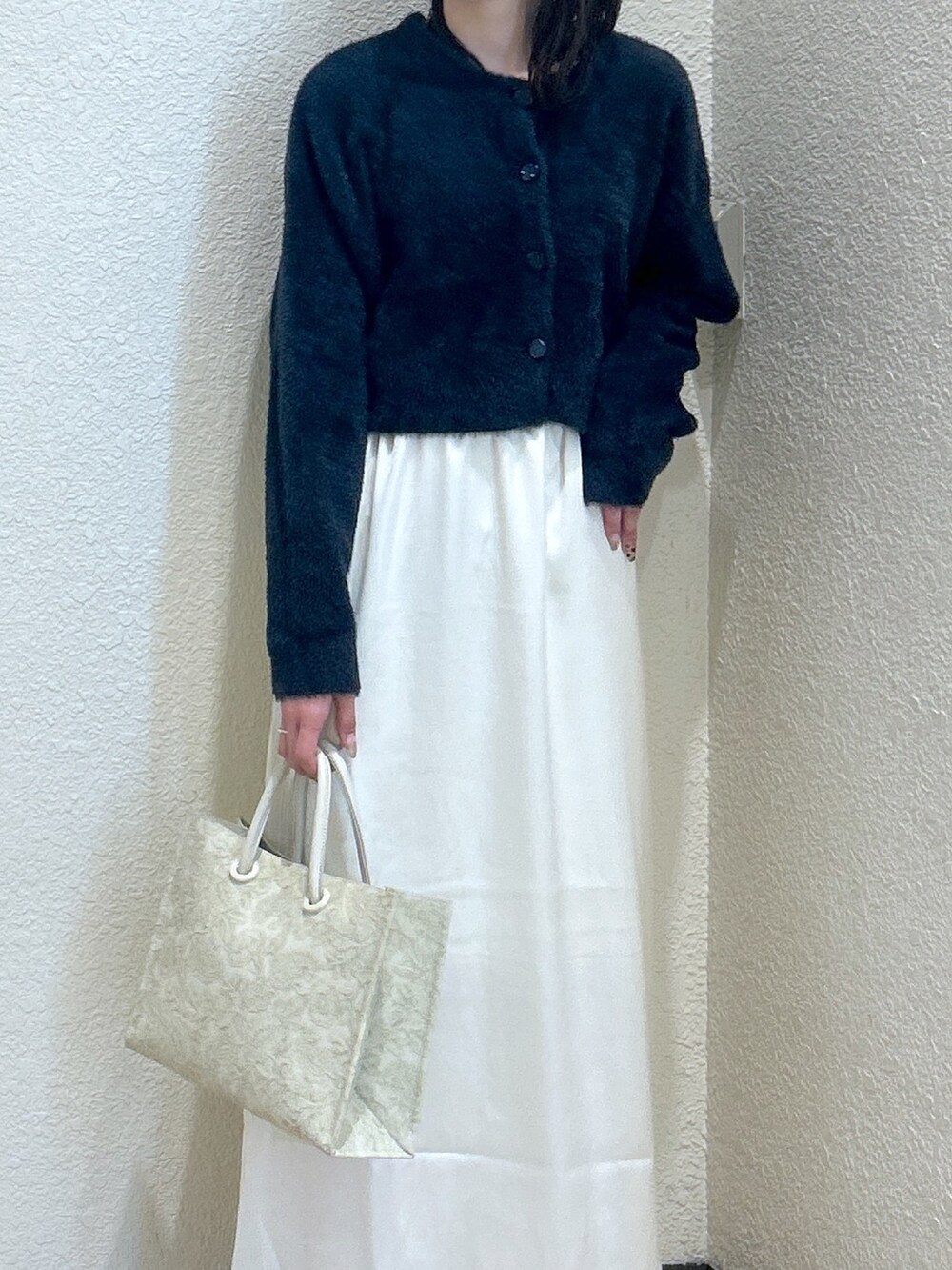 ブルー系のニット/セーター、ホワイト系のスカート、ホワイト系のトートバッグを着用したレディースの秋コーディネートの5枚目の写真