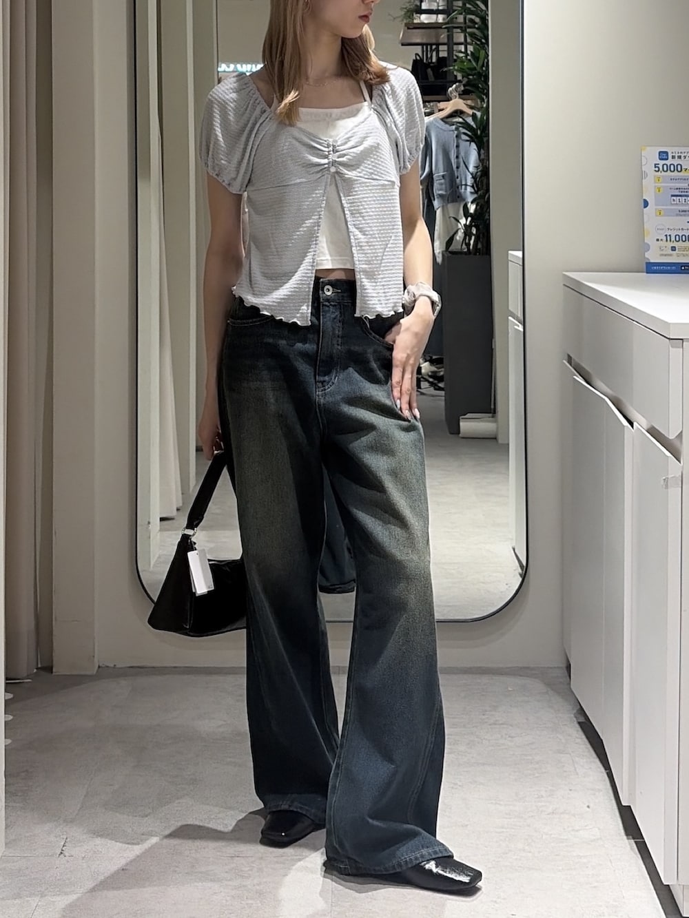 ブルー系のデニムパンツ、ブラック系のパンプス、ブルー系のTシャツ/カットソーを着用したレディースの夏コーディネートの3枚目の写真