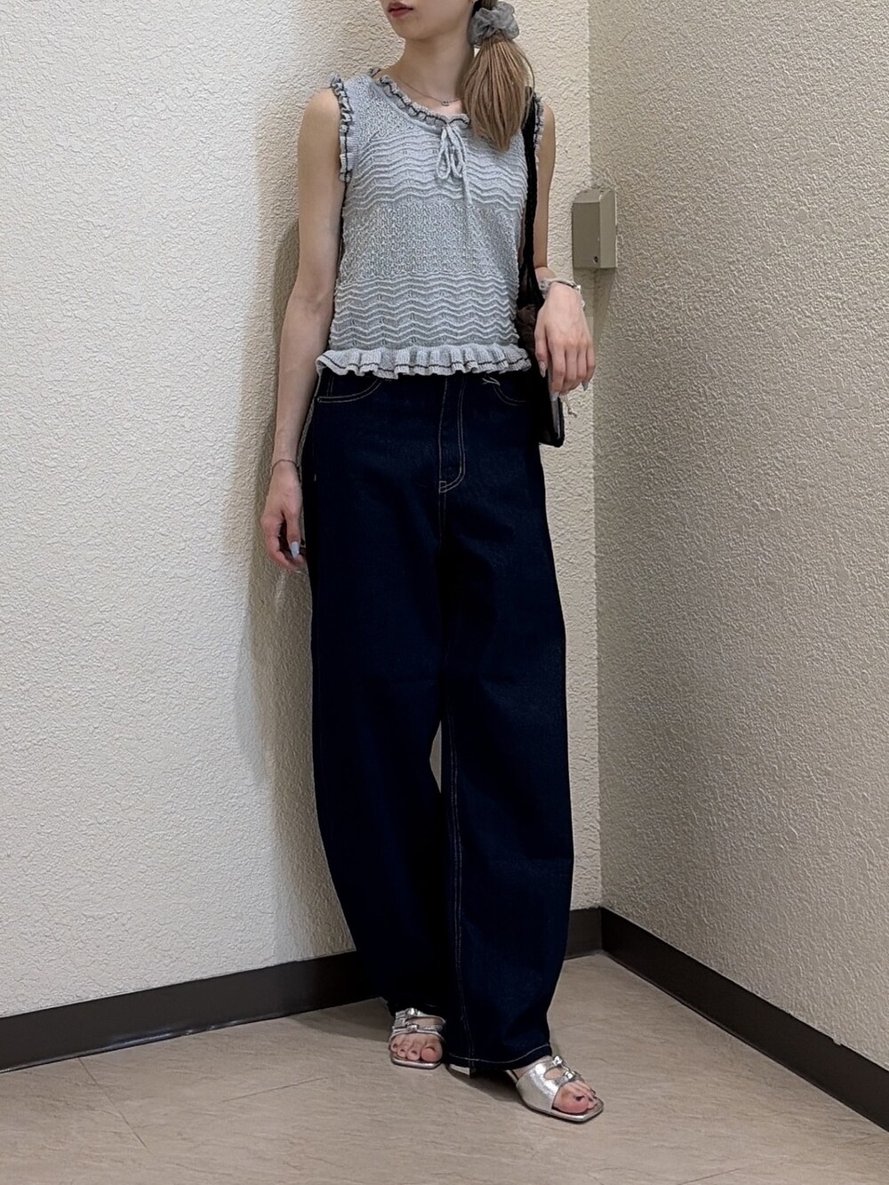 ブルー系のニット/セーター、ブルー系のデニムパンツ、ブラック系のトートバッグを着用したレディースの夏コーディネートの4枚目の写真