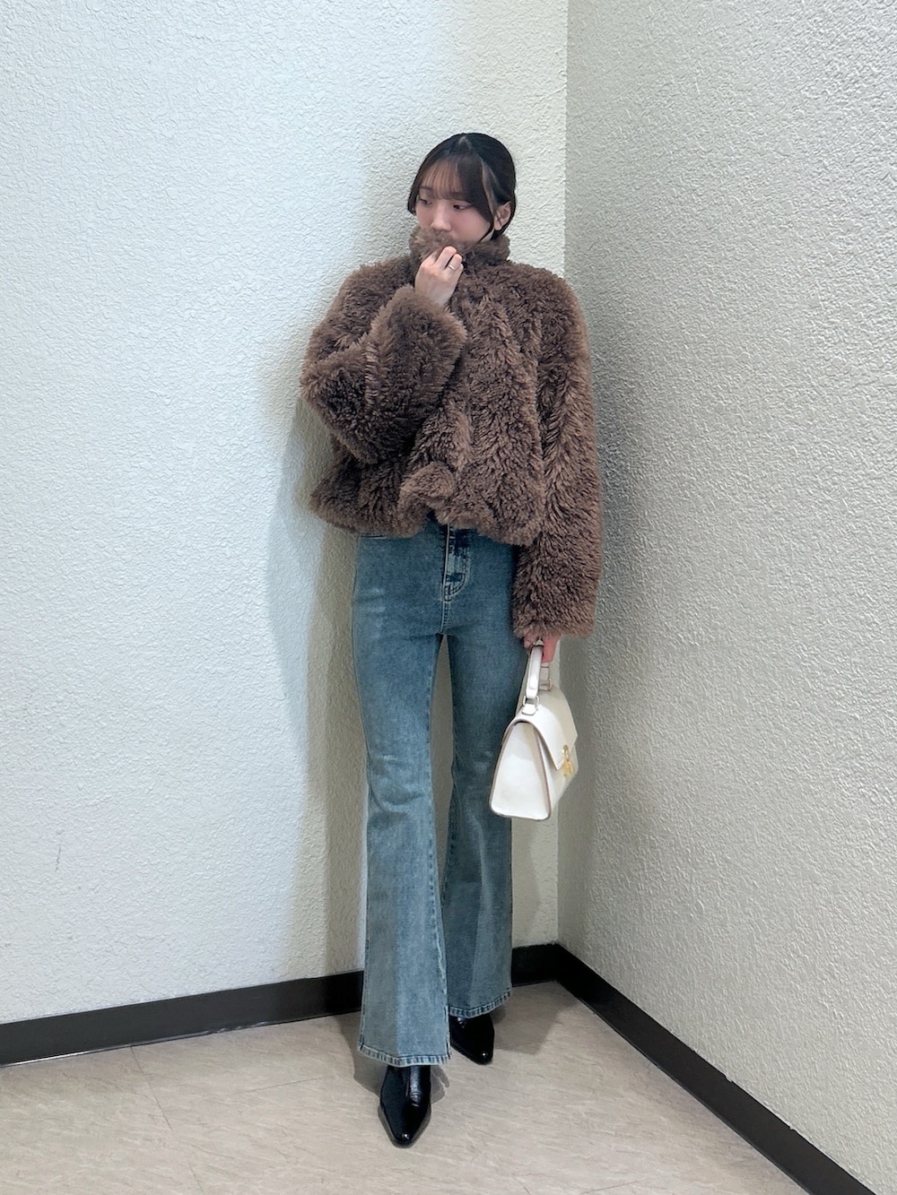 ホワイト系のトートバッグ、ブルー系のデニムパンツ、ブラック系のパンプスを着用したレディースの秋コーディネートの5枚目の写真