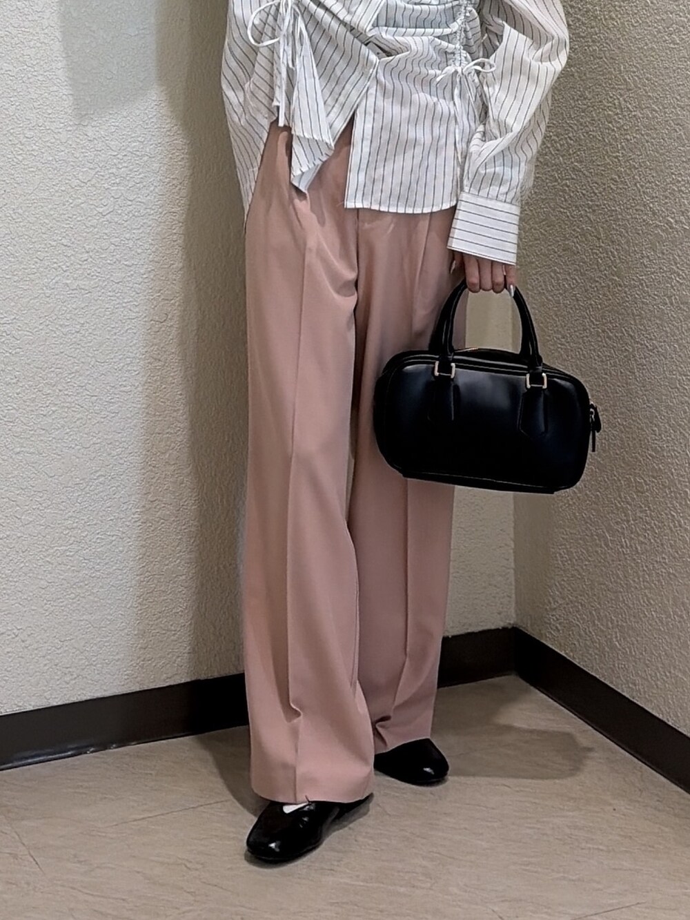 ホワイト系のシャツ/ブラウス、ピンク系のスラックス、ブラック系のハンドバッグを着用したレディースの春コーディネートの6枚目の写真